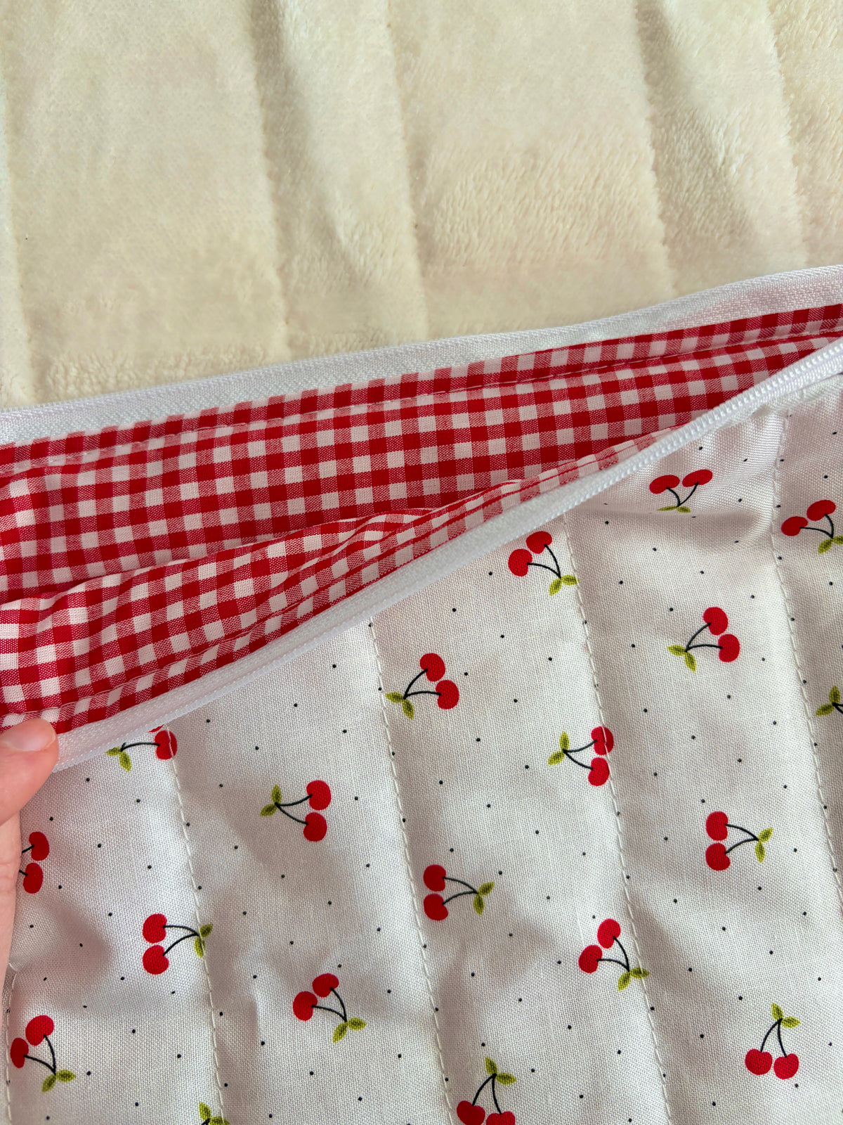 Cherry laptop and tablet sleeve with red-and-white gingham interior lining, curved edge