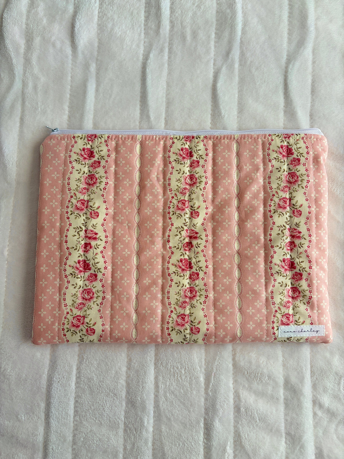 Pink floral laptop sleeve with striped fabric and zip closure