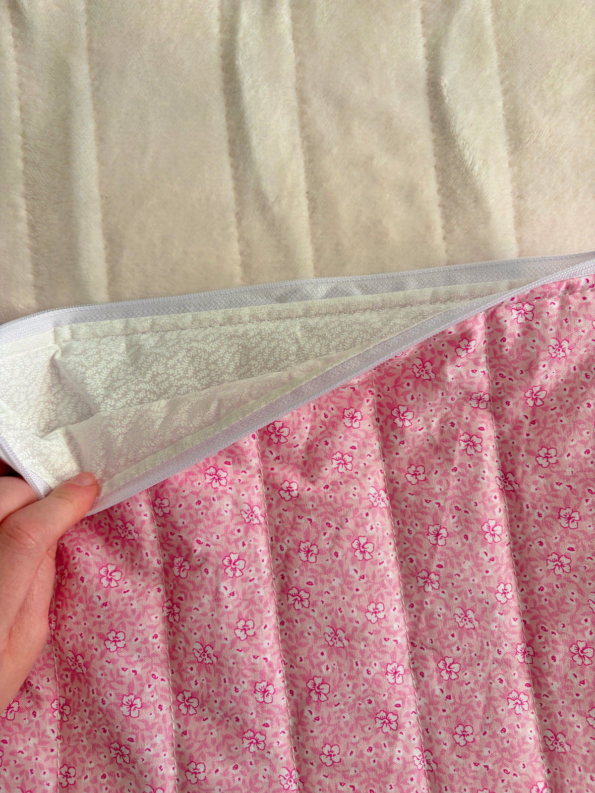 Pink floral laptop sleeve with gray interior lining shown at open edge