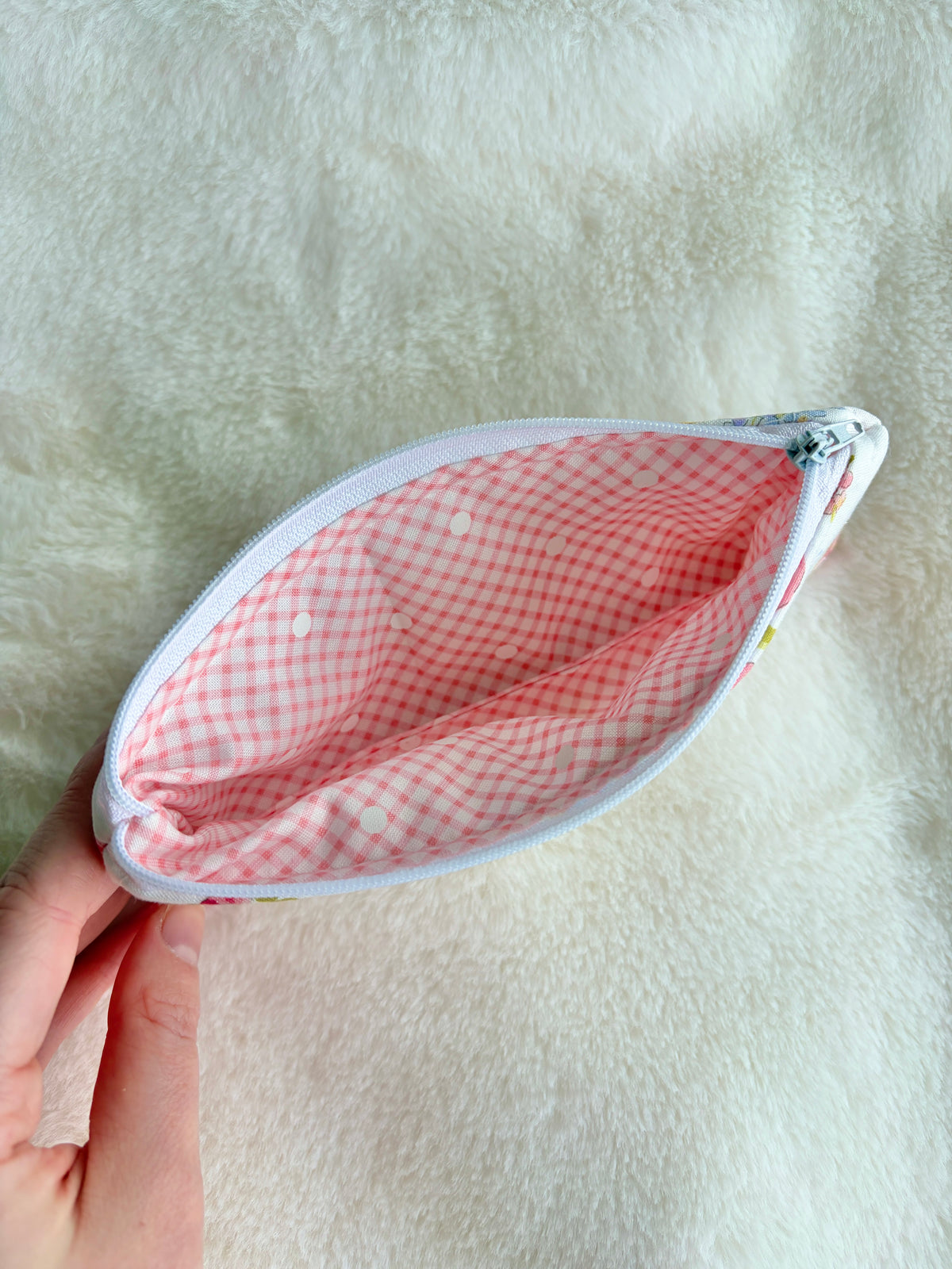Zippered oval glasses case with pink checkered lining, open view