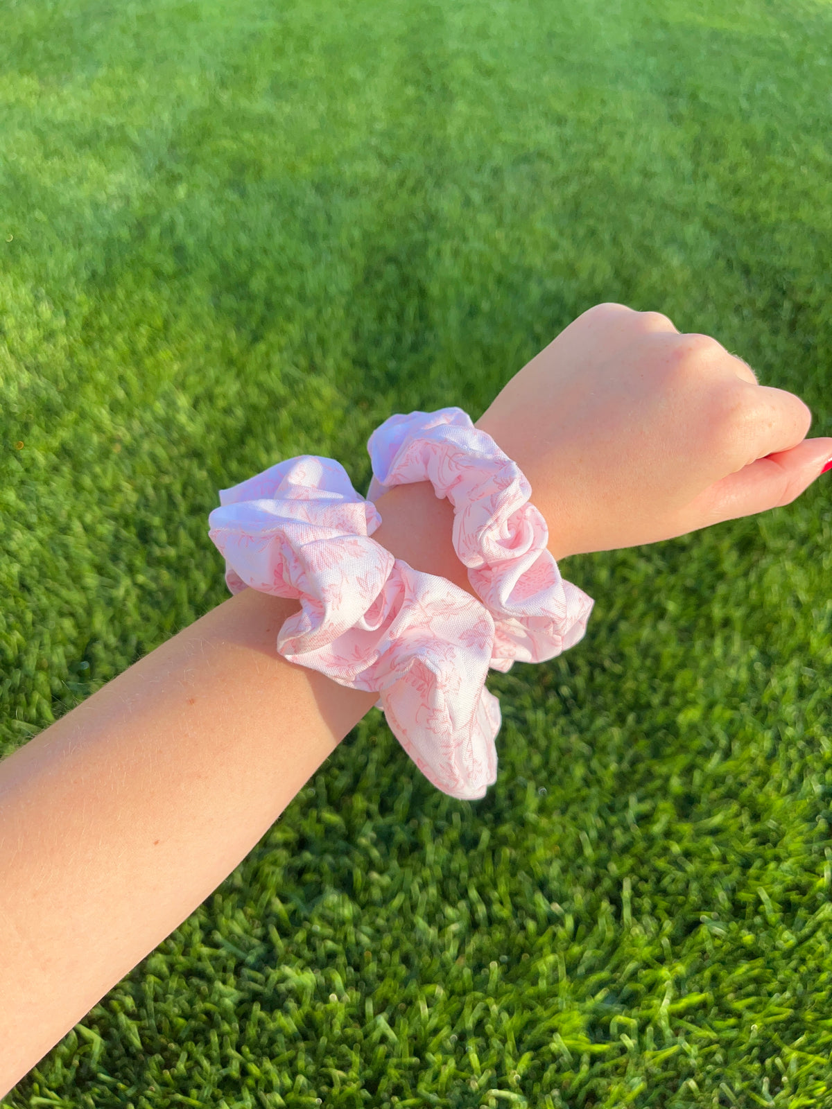 Pink cotton scrunchie on wrist, gathered ruffle with pastel print