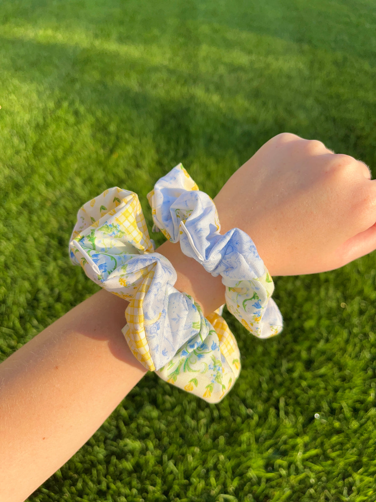 Cotton patchwork scrunchie with light blue, yellow, and green sections, on arm.