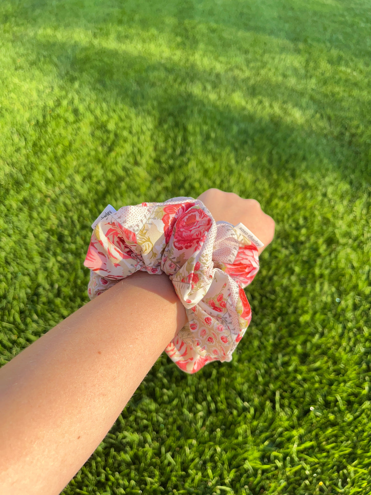 Rosette cotton scrunchie on wrist, pink and red floral print