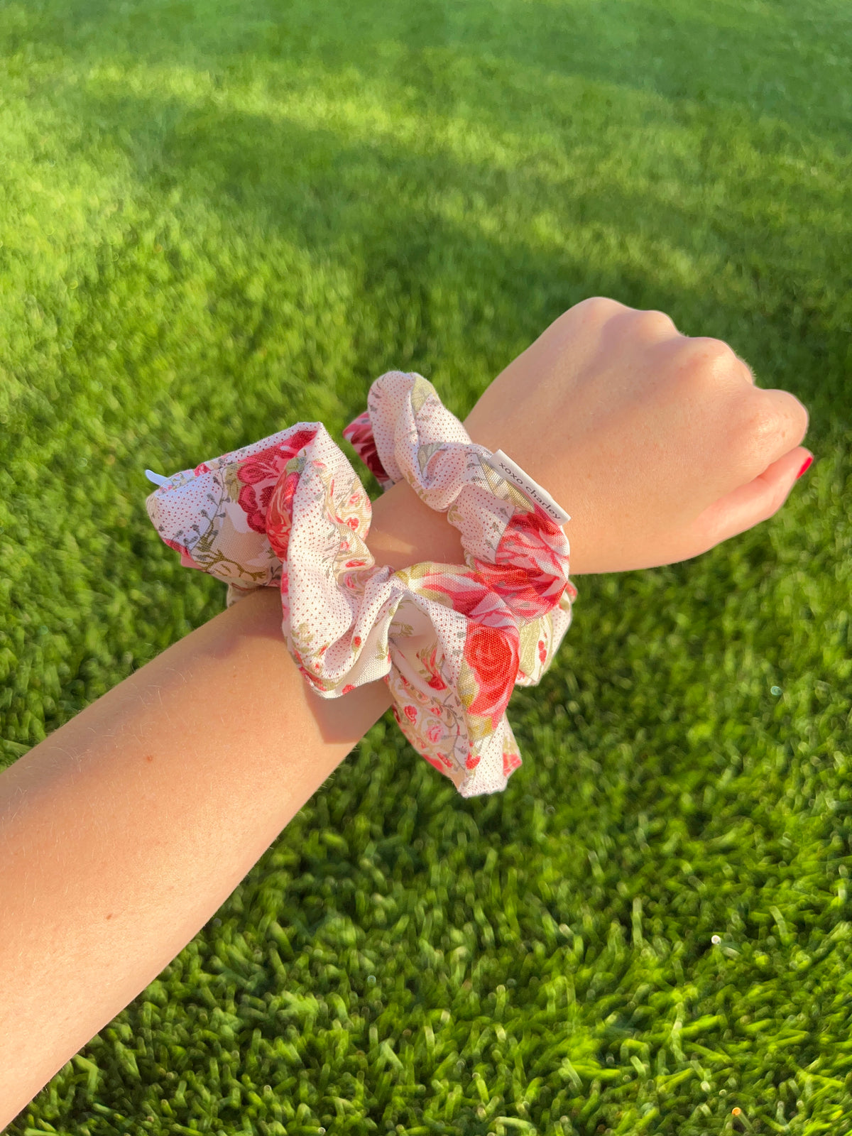 Rosette cotton scrunchie on wrist, pink and red floral print