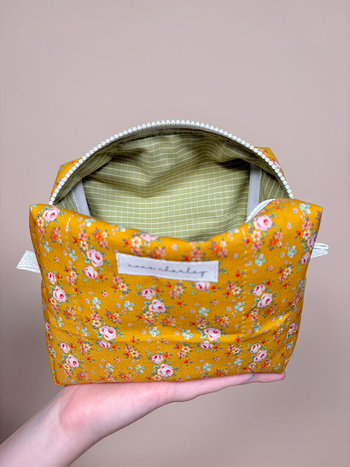Medium makeup bag, orange floral print with open top and green plaid lining