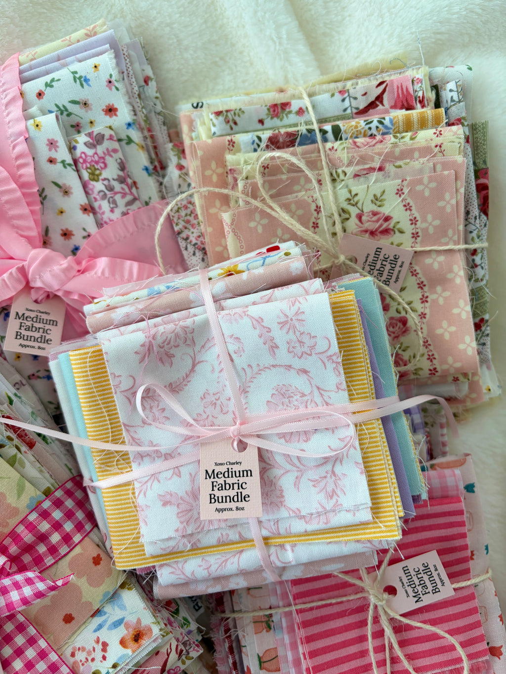 Pastel floral fabric bundle with gingham pieces and a ribbon-tied center stack