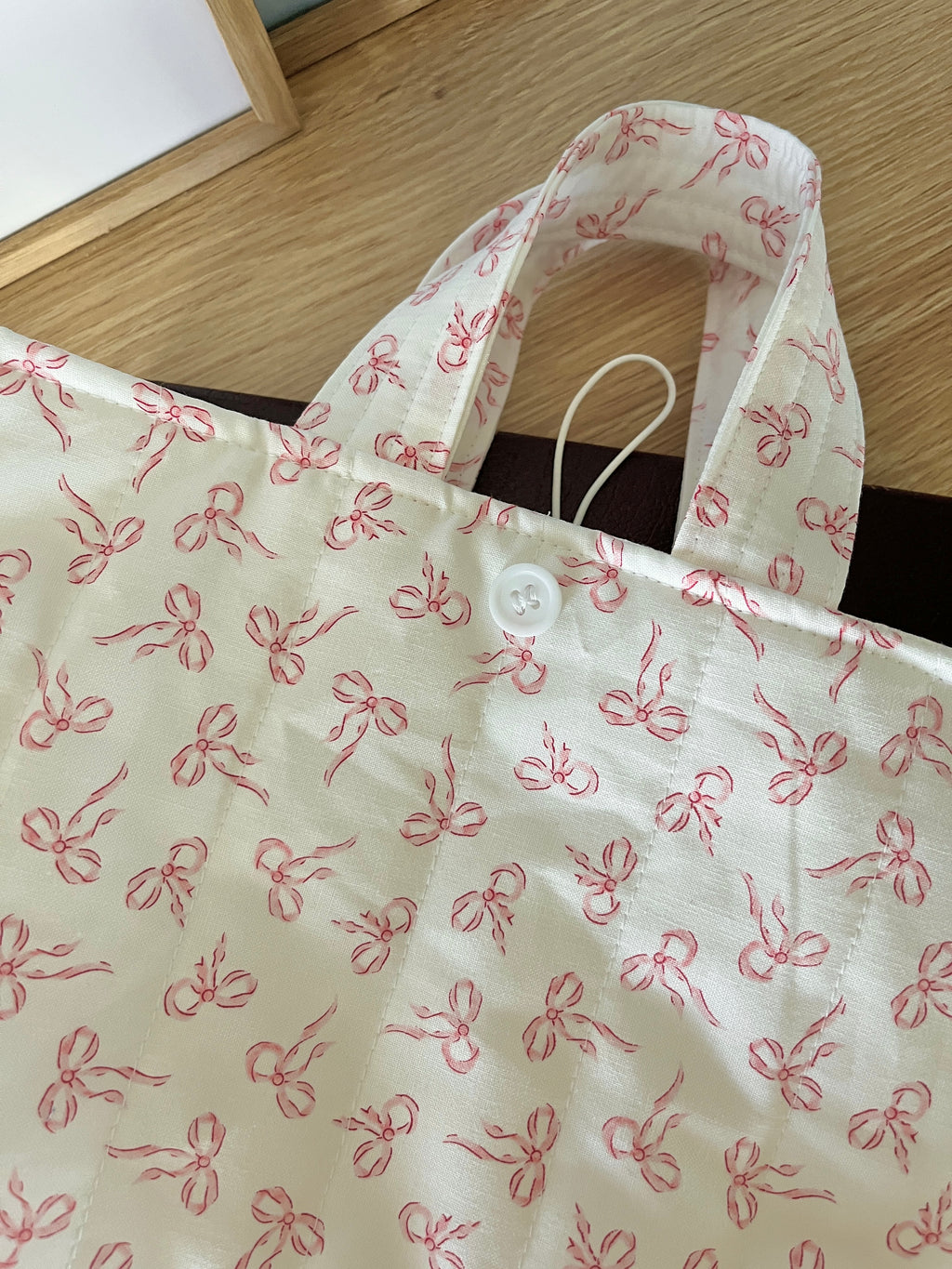 Mini bible tote bag with pink bow print and side handles, open top