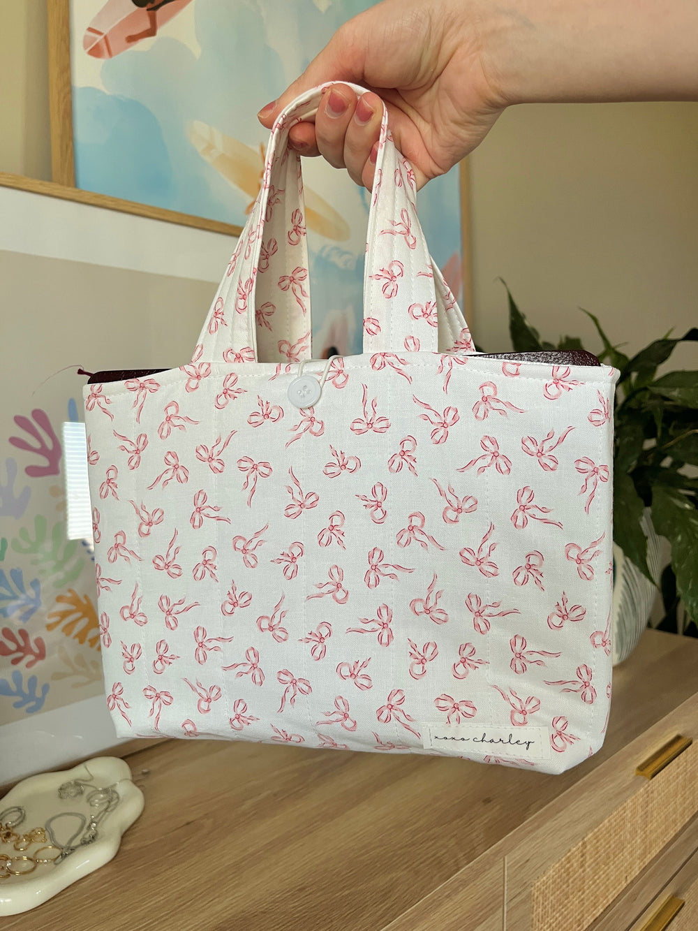 Pink bow mini bible tote bag held by the handles, open top