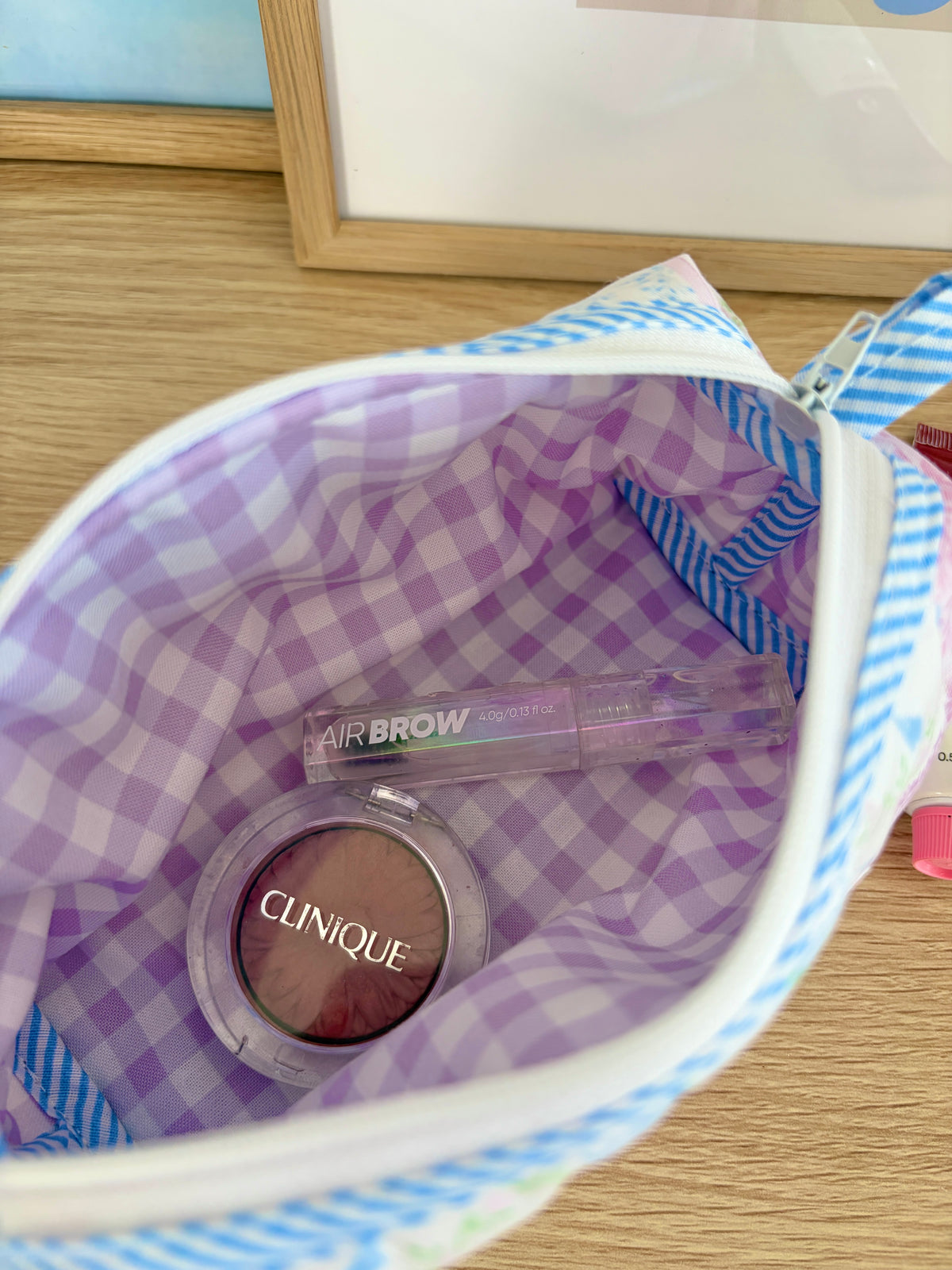 Patchwork cosmetic bag open, purple gingham lining with AIRBROW and Clinique