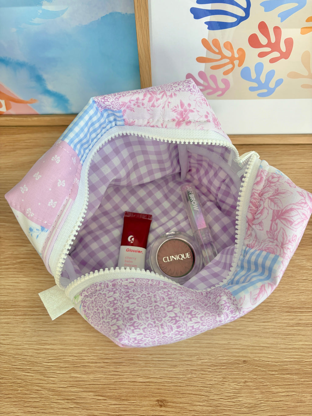 Medium makeup bag open, showing purple plaid lining and inner pockets