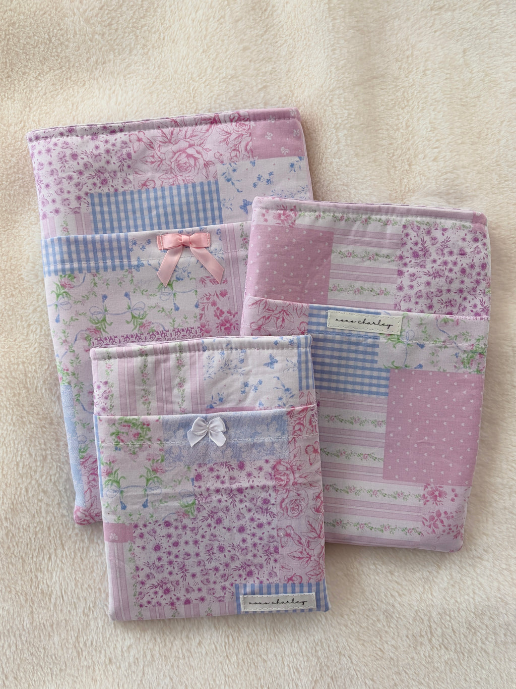 Pink patchwork e-reader/book sleeve with stitched bow front, fabric-lined pages