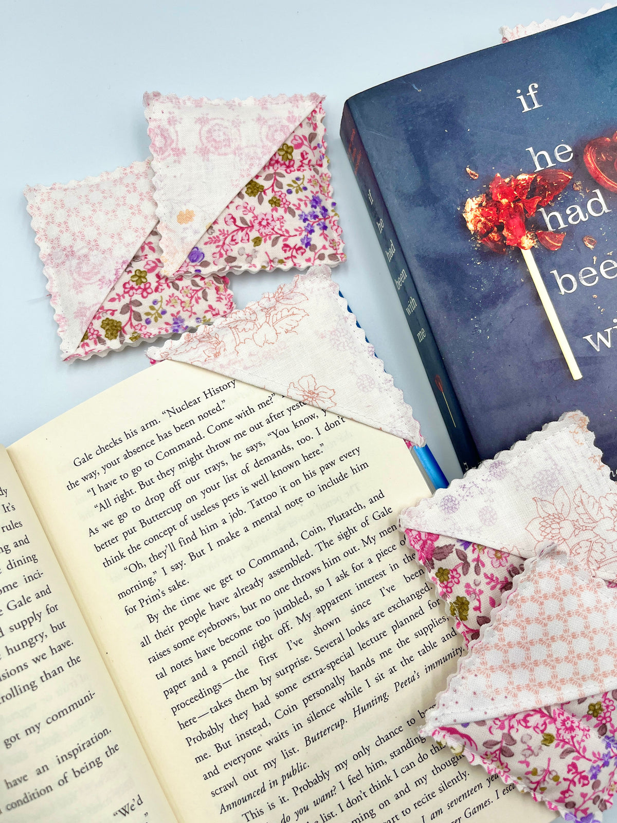 Pink floral fabric corner bookmark with scalloped edge, shown on a book page