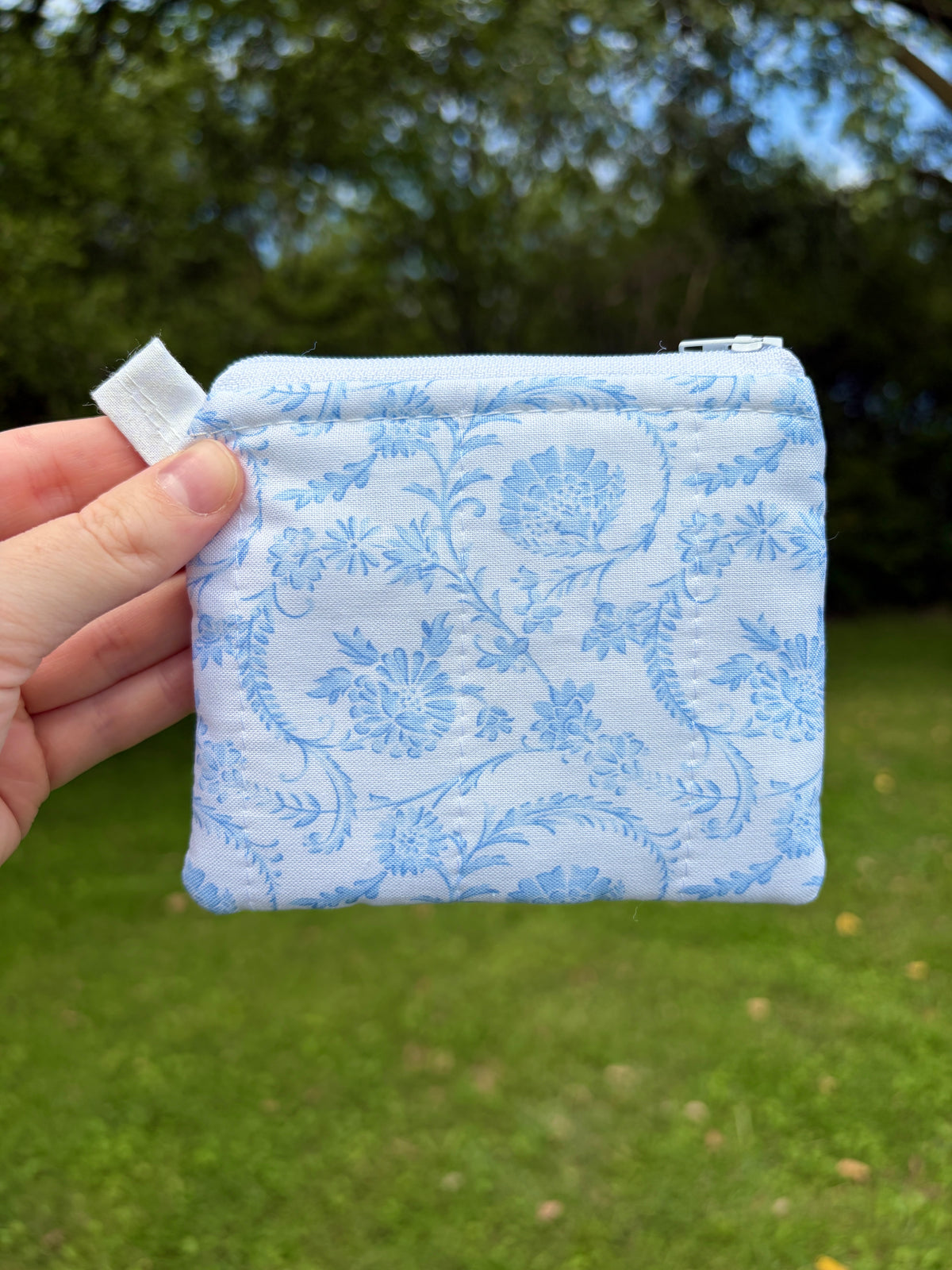 Light blue floral zip wallet pouch with fabric tab pull