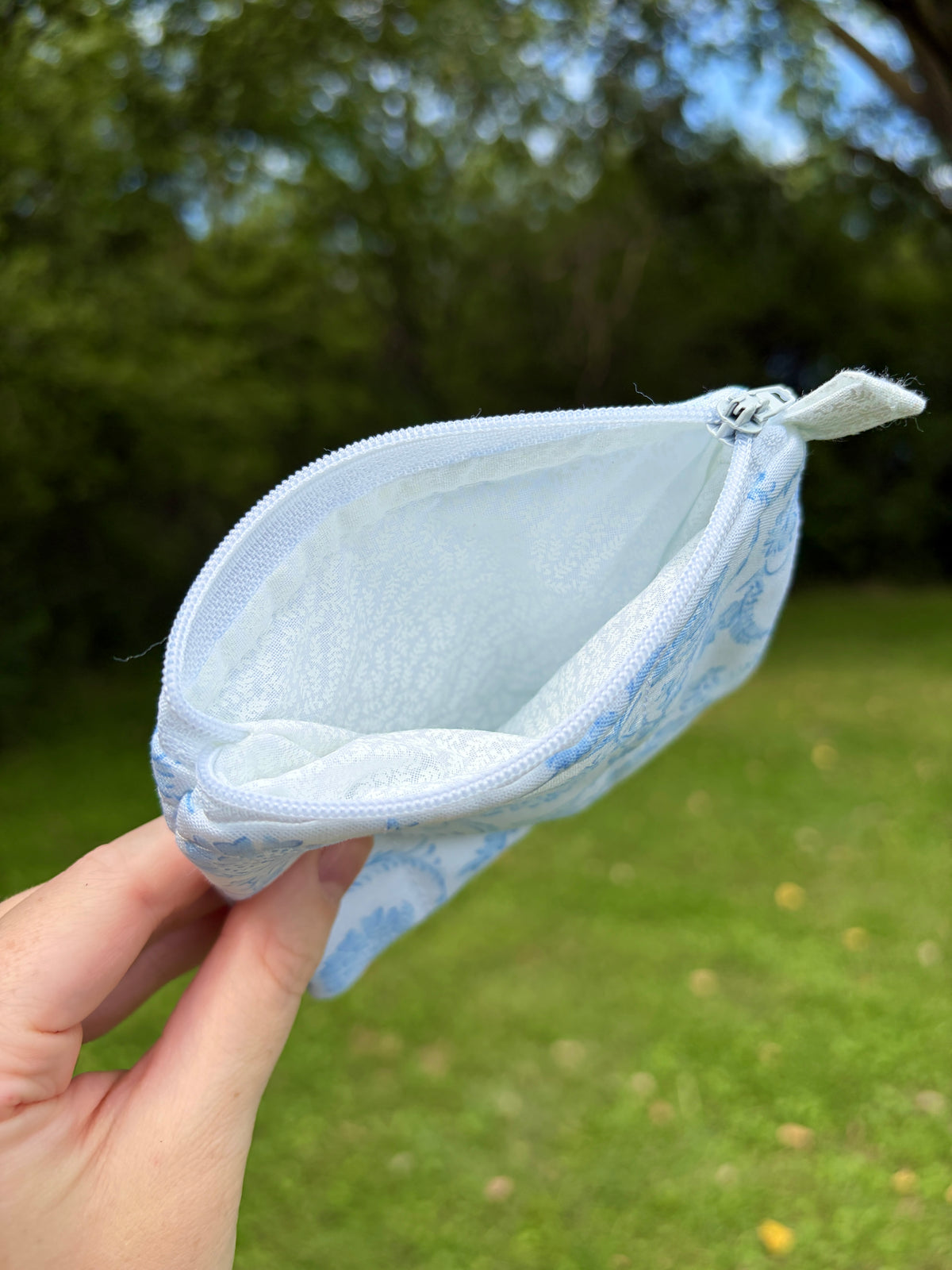 Blue floral zip wallet pouch showing light interior lining