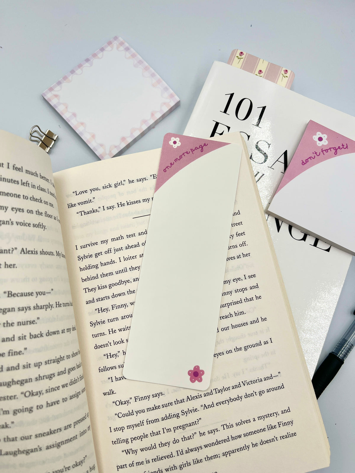 Pink and blue bookmark with floral corner design and printed text