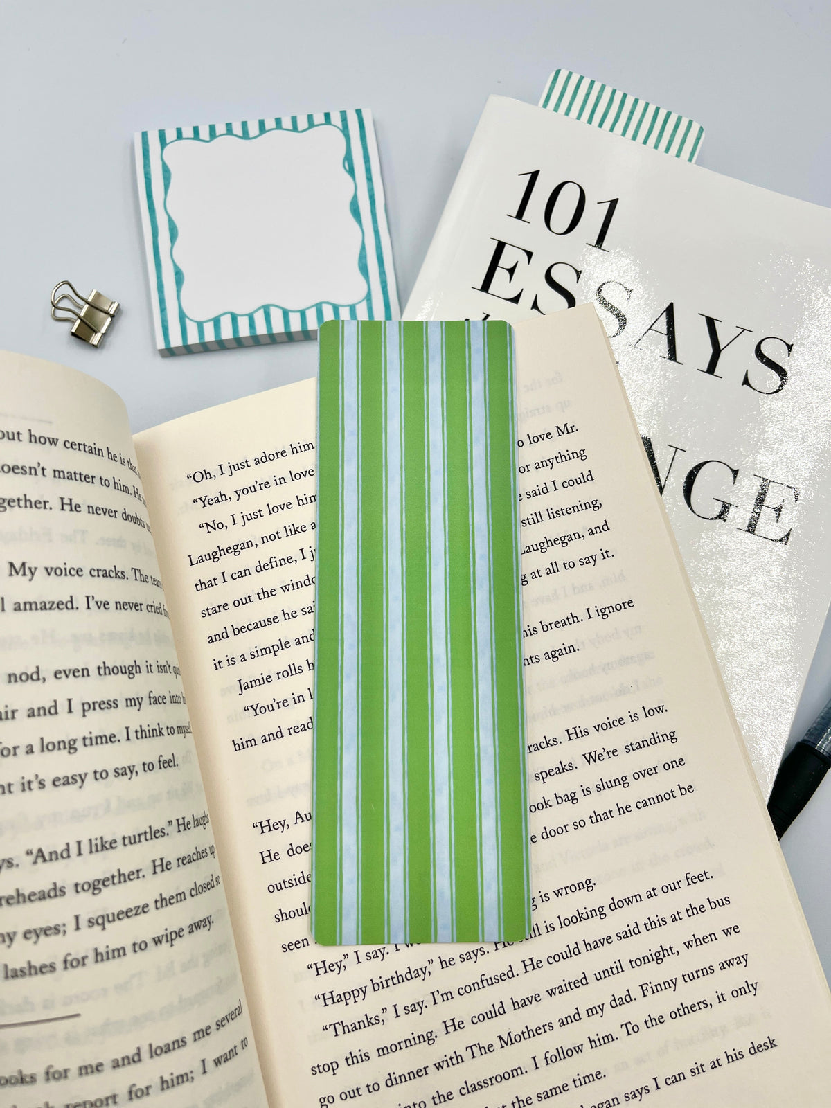 Green and white striped bookmark standing upright on book pages