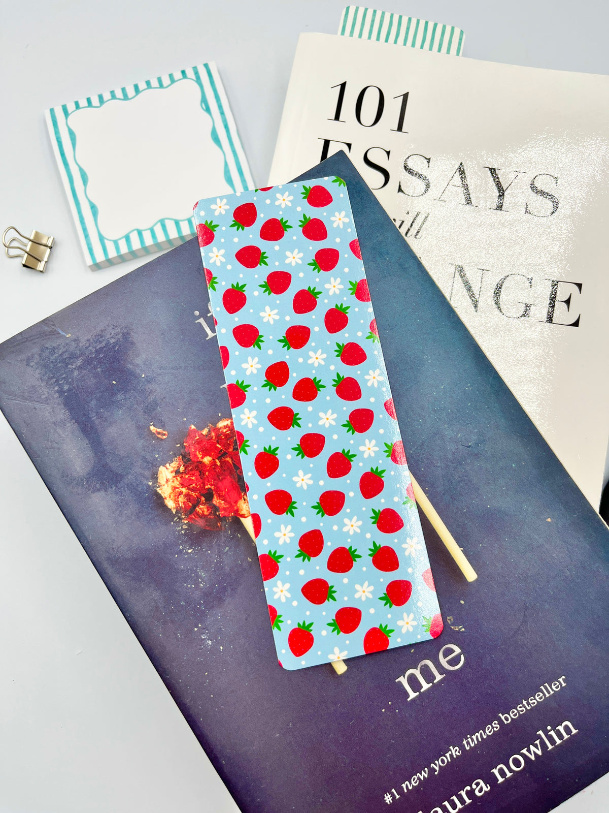 Strawberry-patterned fabric bookmark on a blue backing with wooden stick