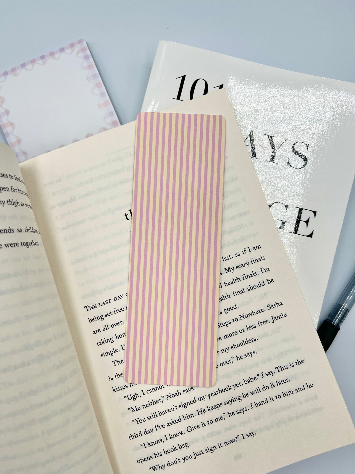 Pink and yellow vertical striped paper bookmark with clean straight edge