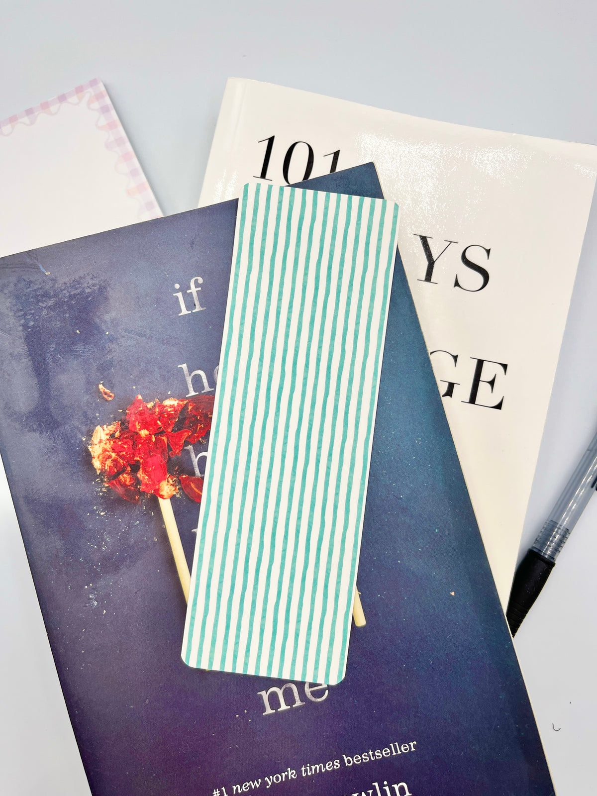 Teal striped bookmark with vertical white stripes, narrow rectangular shape