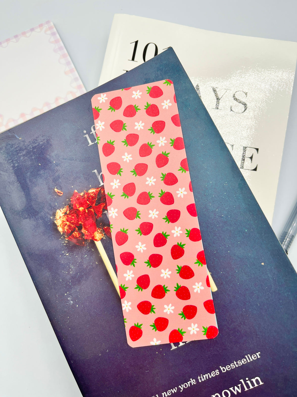 Strawberry print bookmark on dark blue backing, pink red strawberries pattern