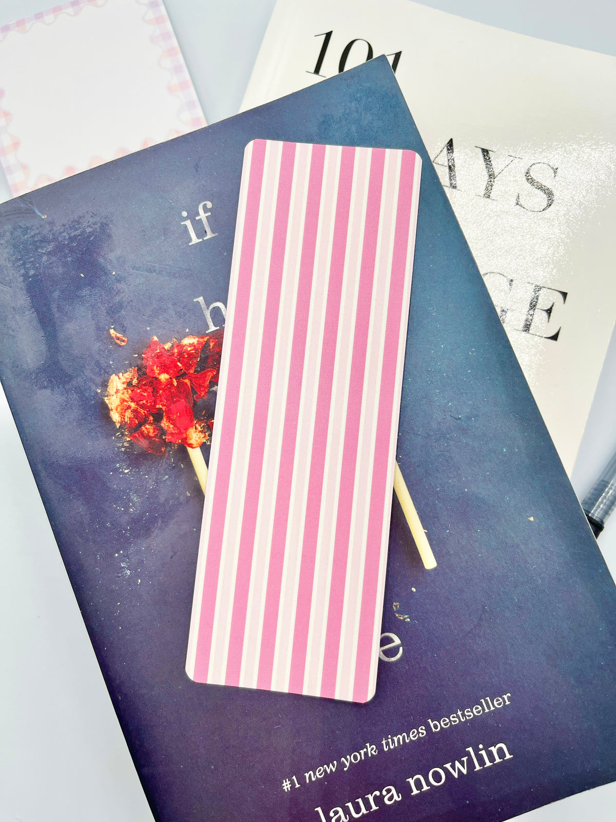 Paper bookmark with pink vertical stripes and white center panel
