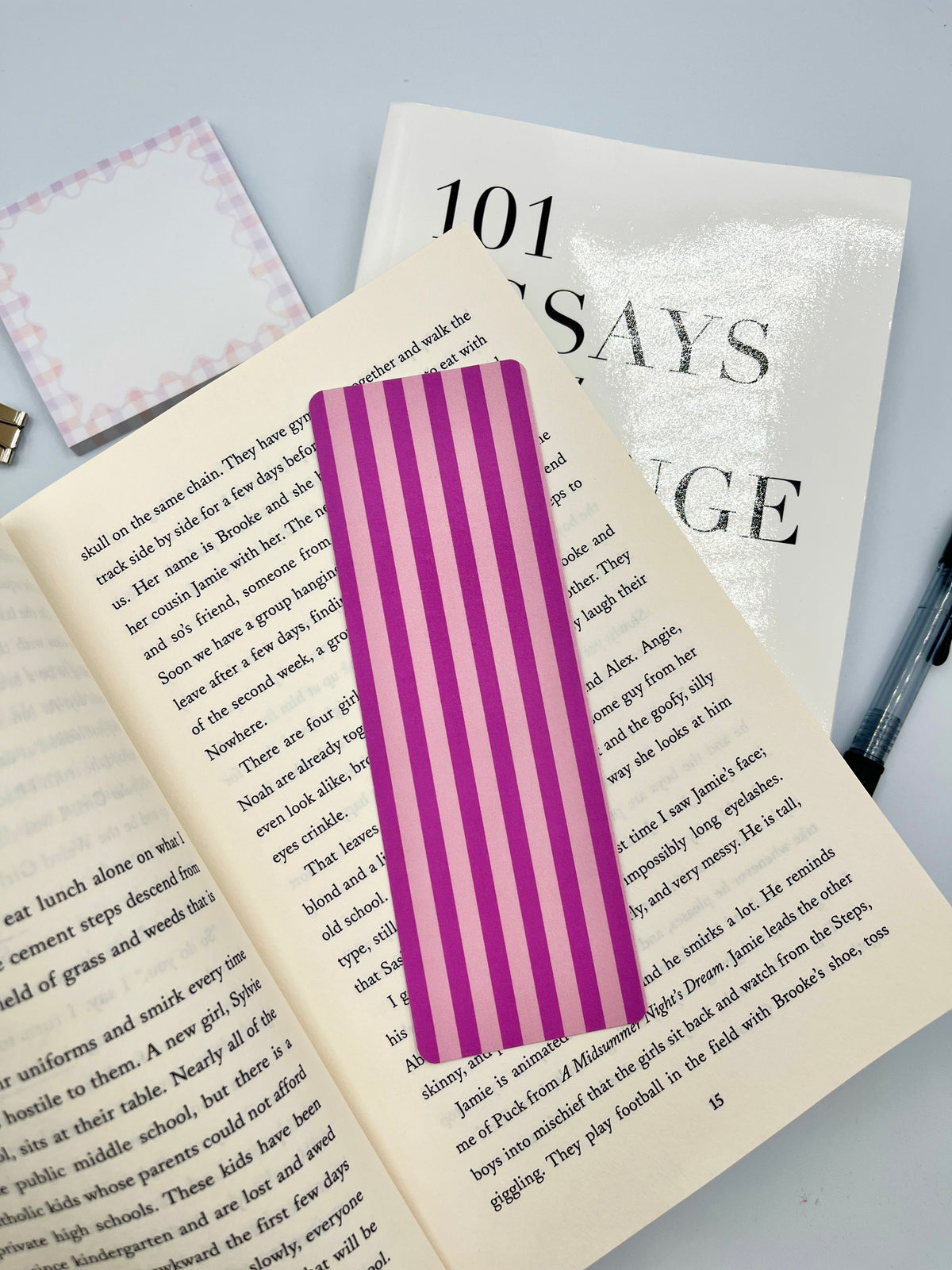 Purple striped bookmark displayed on open book pages, rectangular page marker