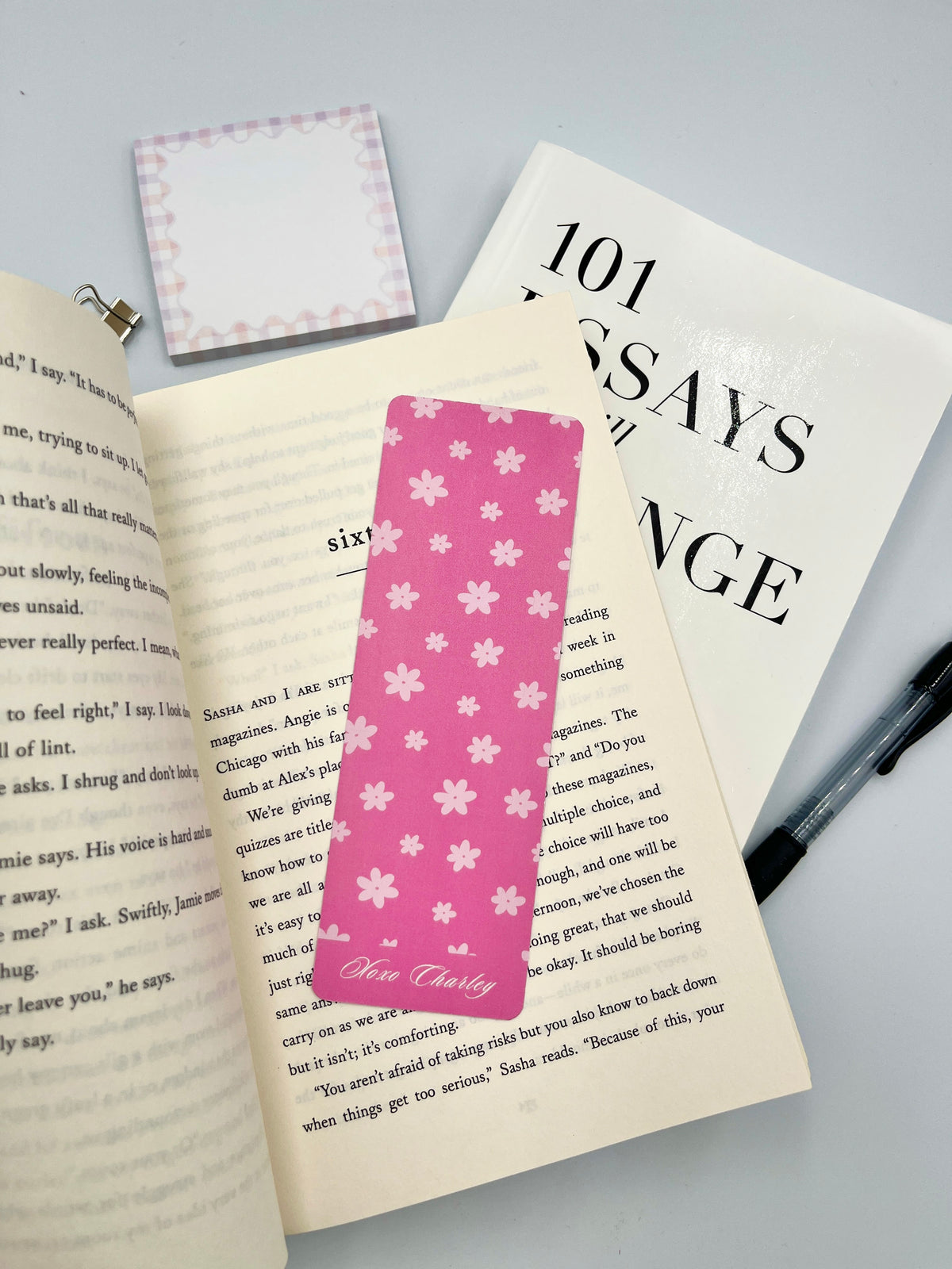 Pink floral bookmark with white flower pattern and Charley script on bottom