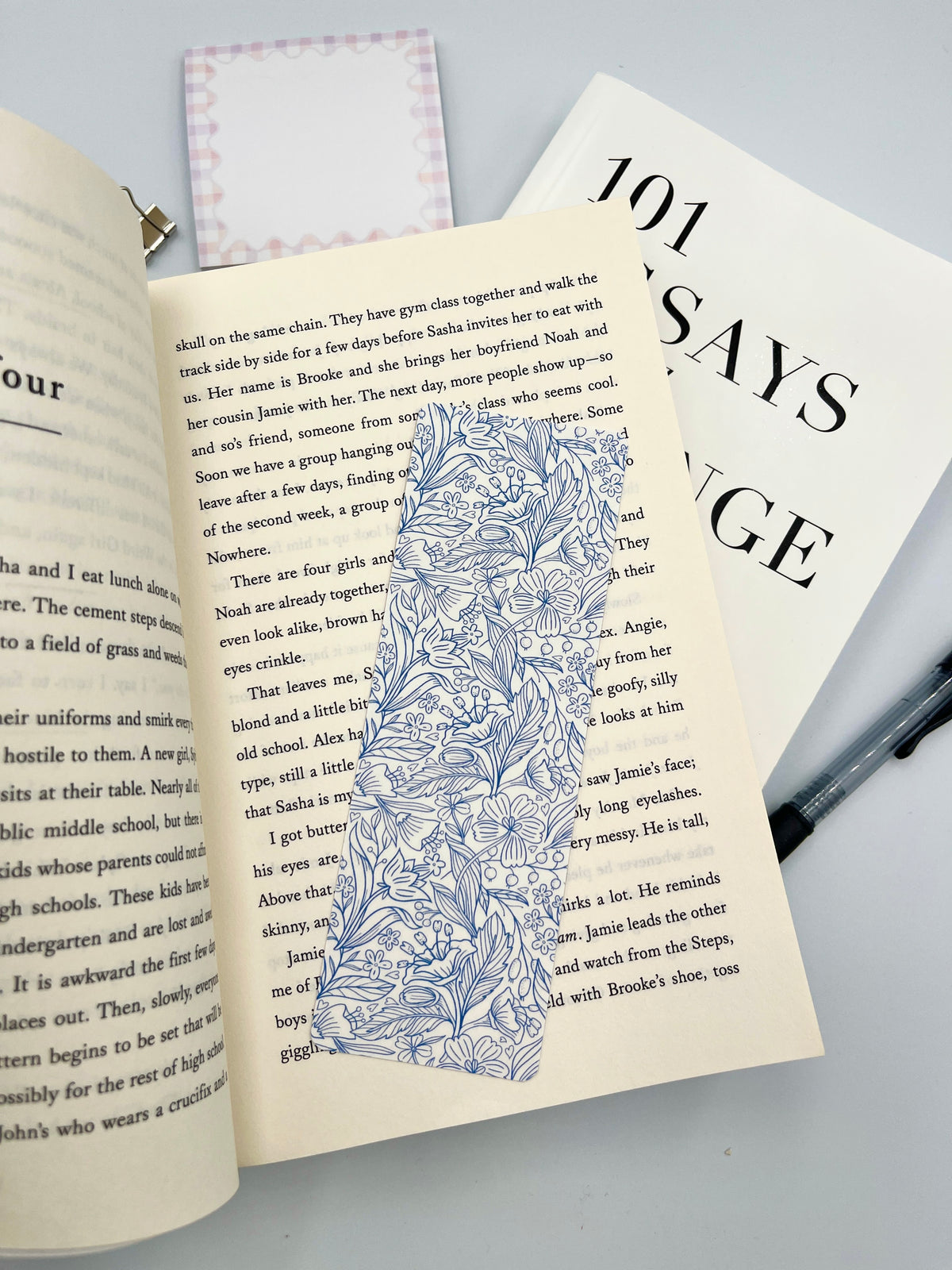 Rectangular blue doodle-pattern bookmark placed on open book