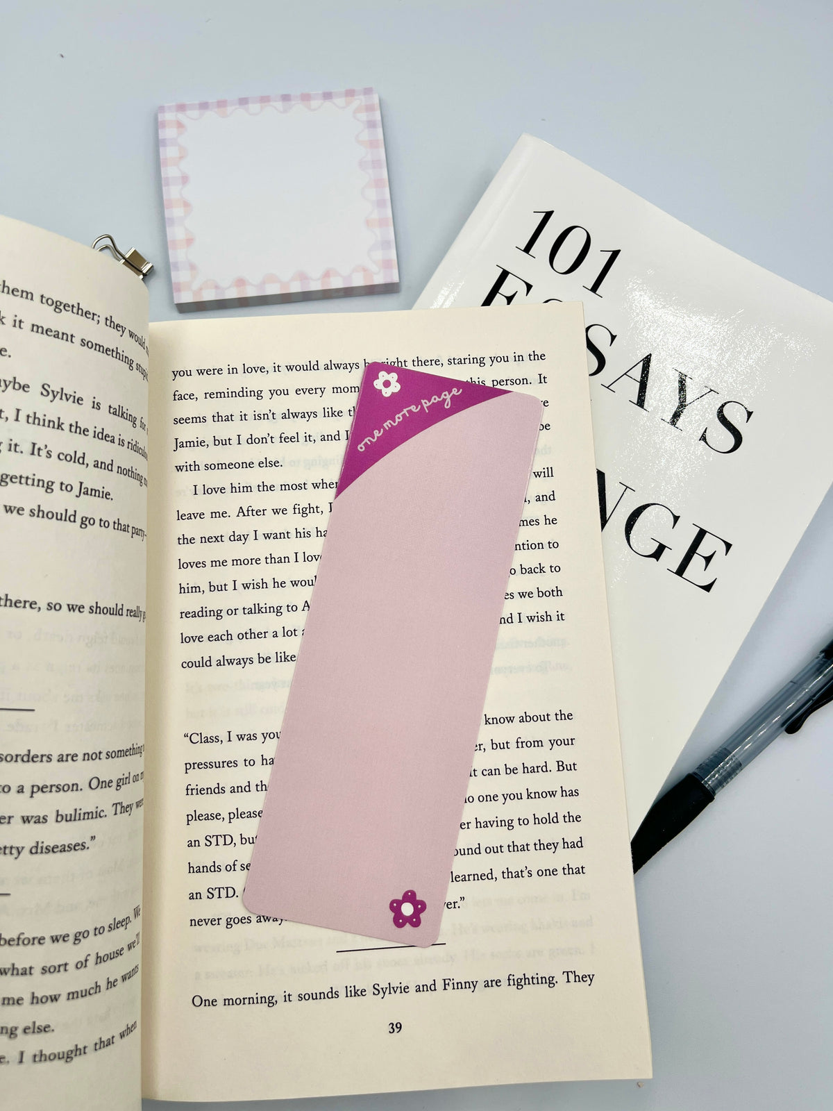 Purple bookmark with flower emblem on open book pages