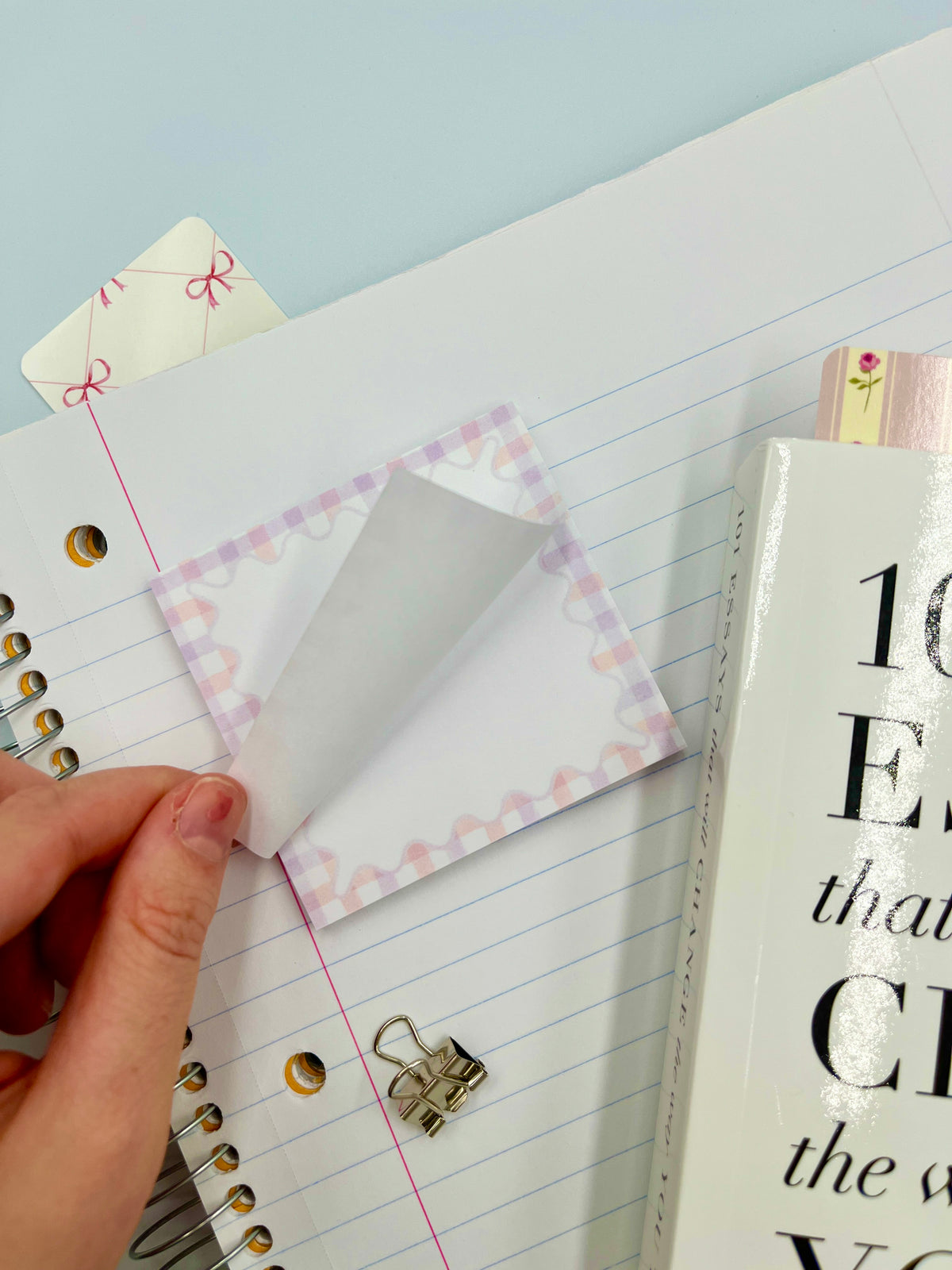 Pastel gingham sticky note with pink gingham edge, lifted corner in hand
