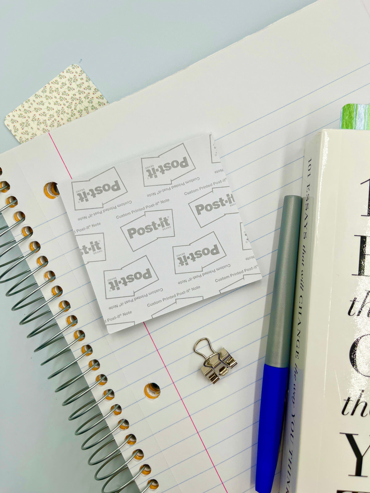 Square sticky note sheets with Post-it logo on lined notebook paper