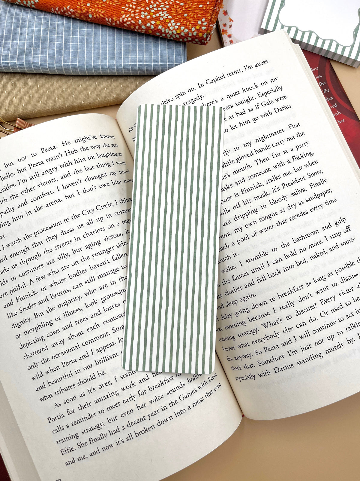 White bookmark with green vertical stripe panel, tucked between book pages