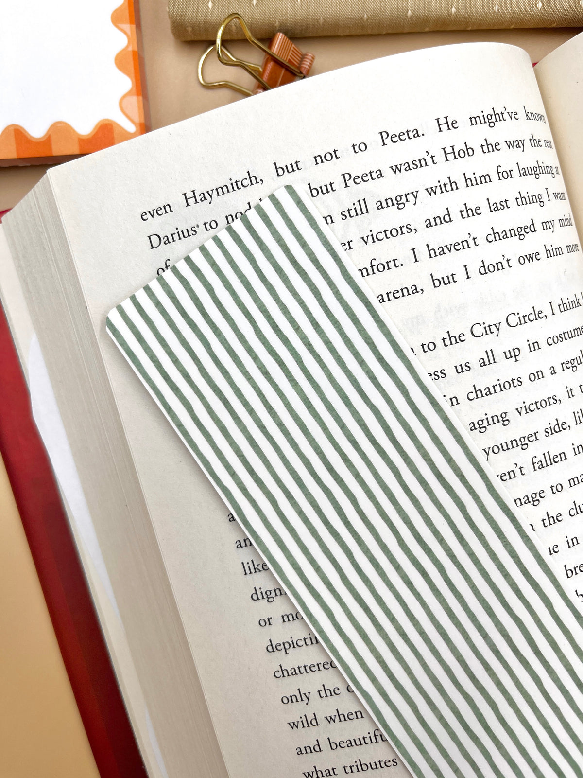 Green-striped bookmark on a white paper tab, resting on an open book