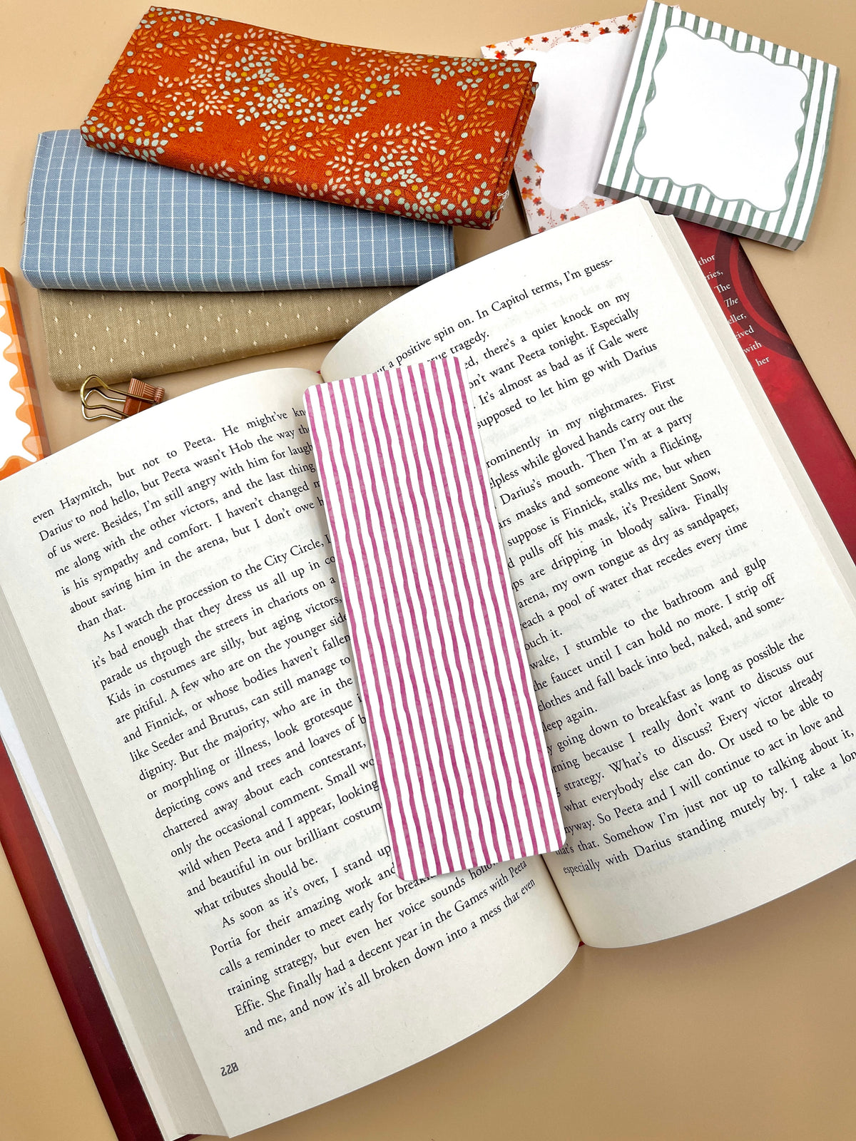 Plum striped bookmark with vertical magenta-and-white stripes in an open book.