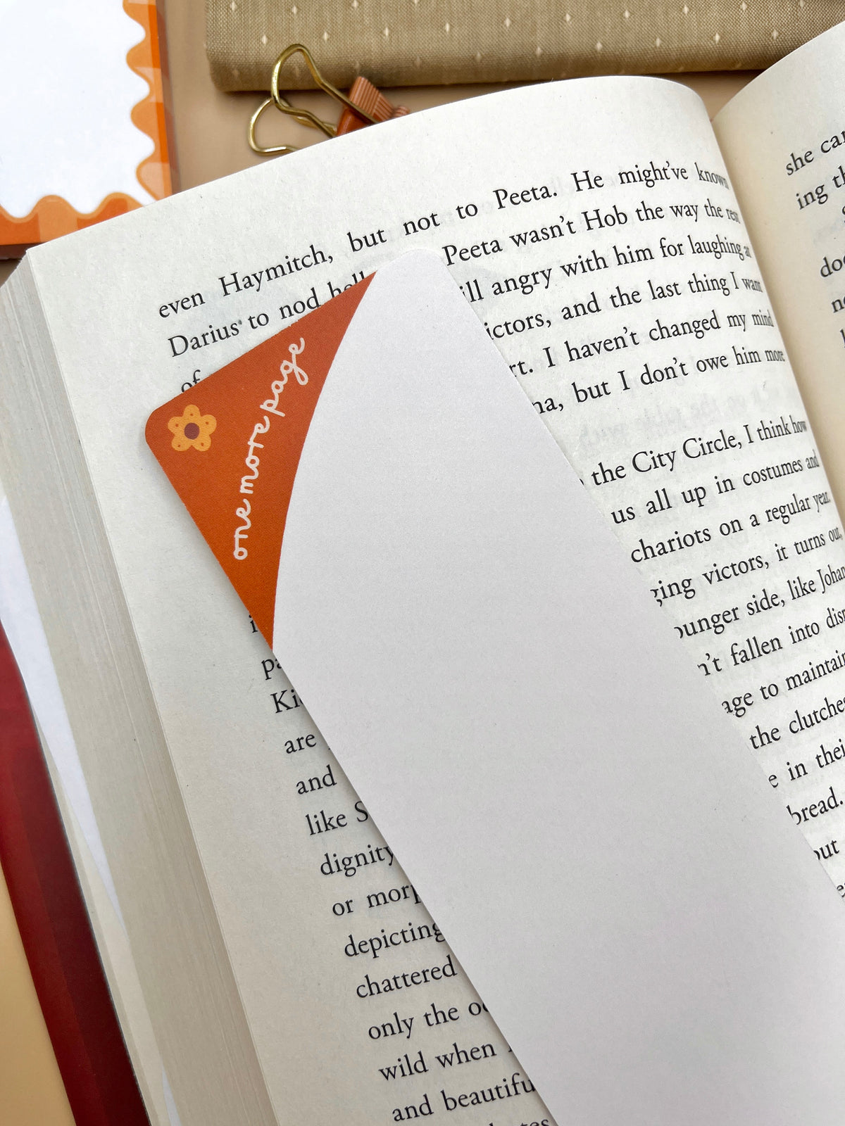 Limited-edition autumn bookmark with orange flower design on book page corner