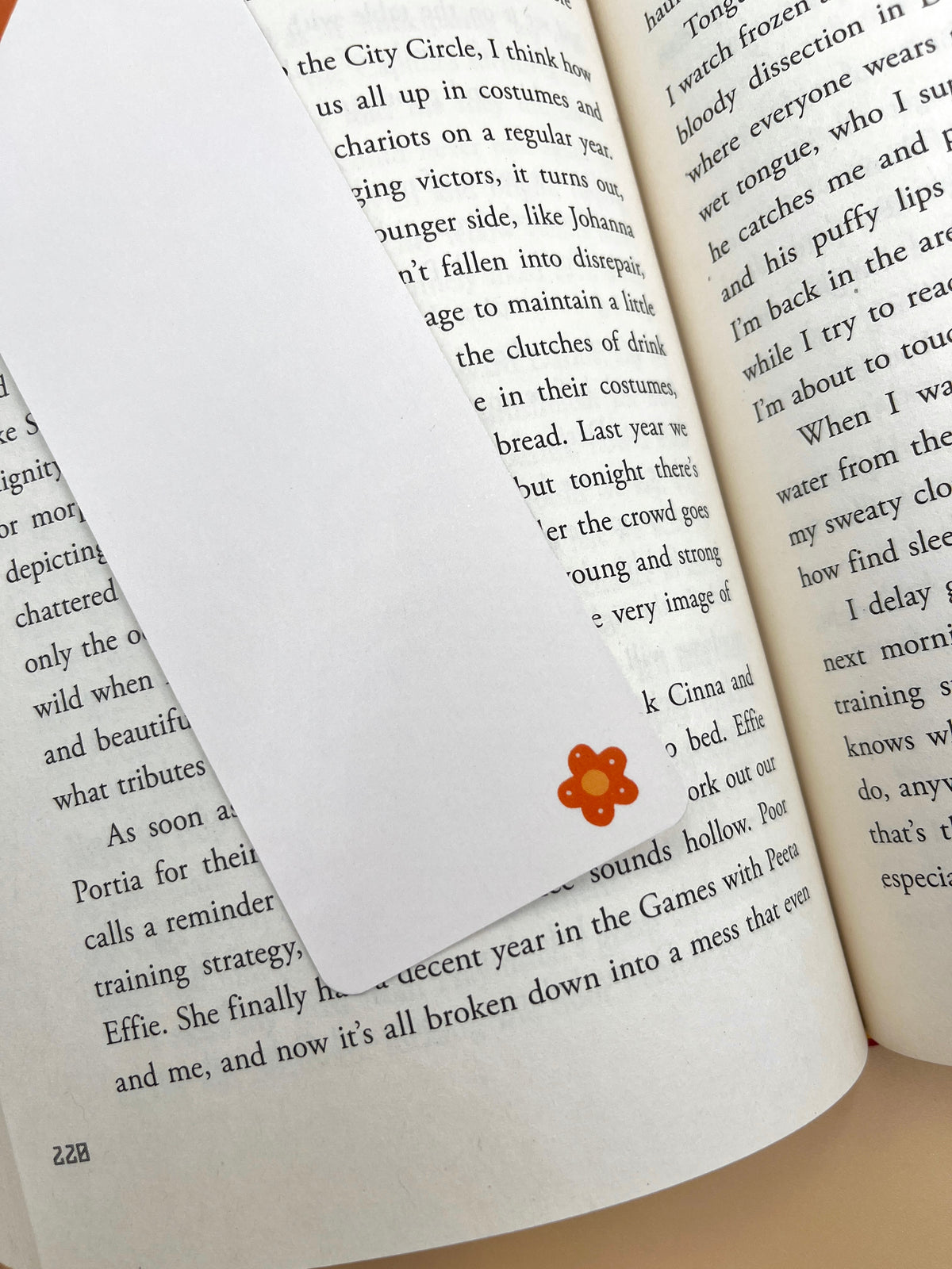 Orange flower limited-edition bookmark clipped to open book pages for reading