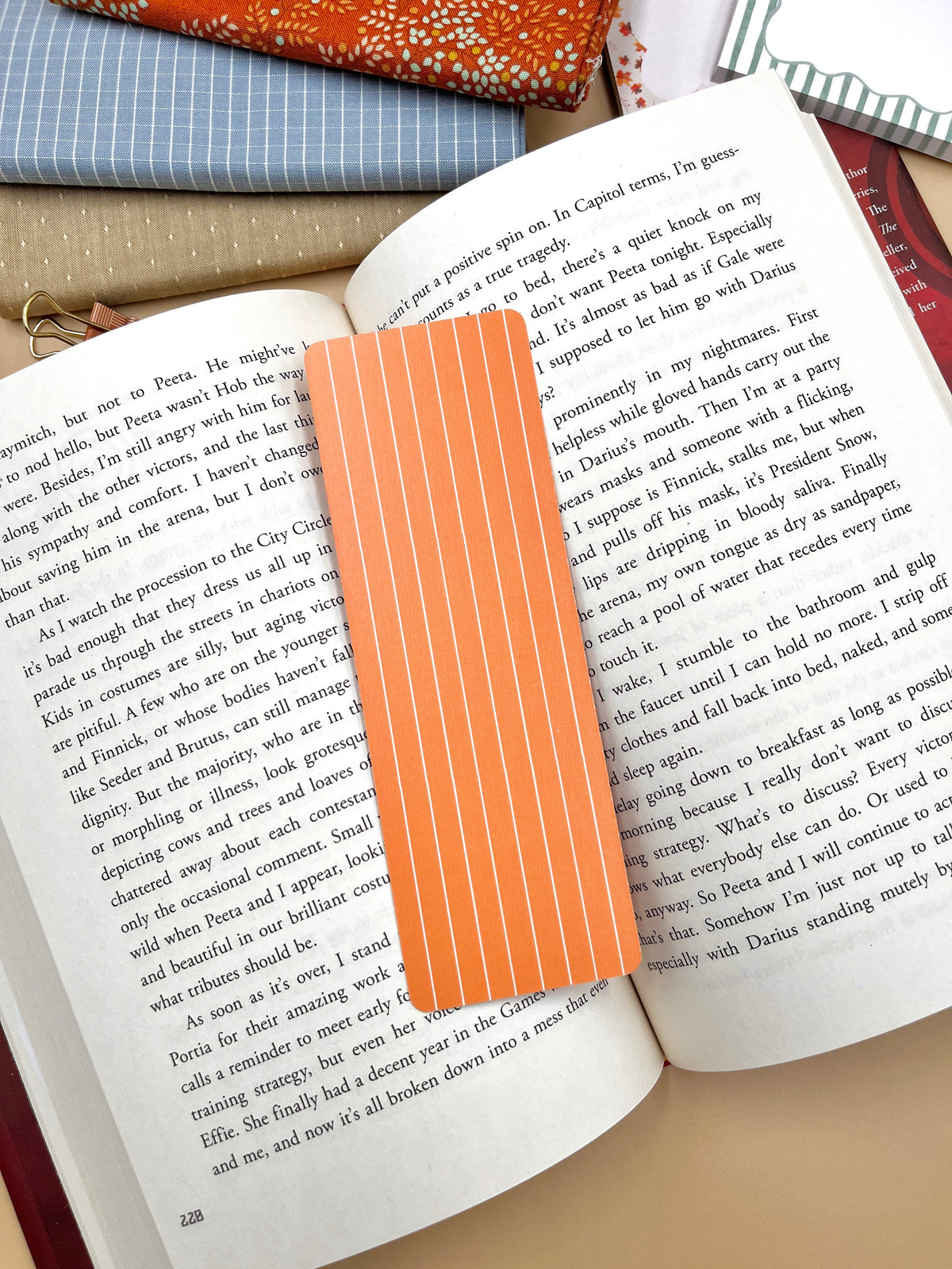 Orange striped pumpkin bookmark with scalloped top between open book pages