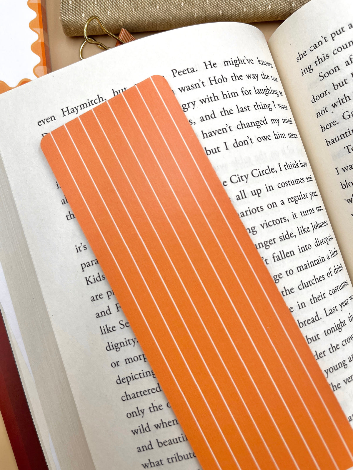 Orange vertical striped pumpkin bookmark on open book page, close-up