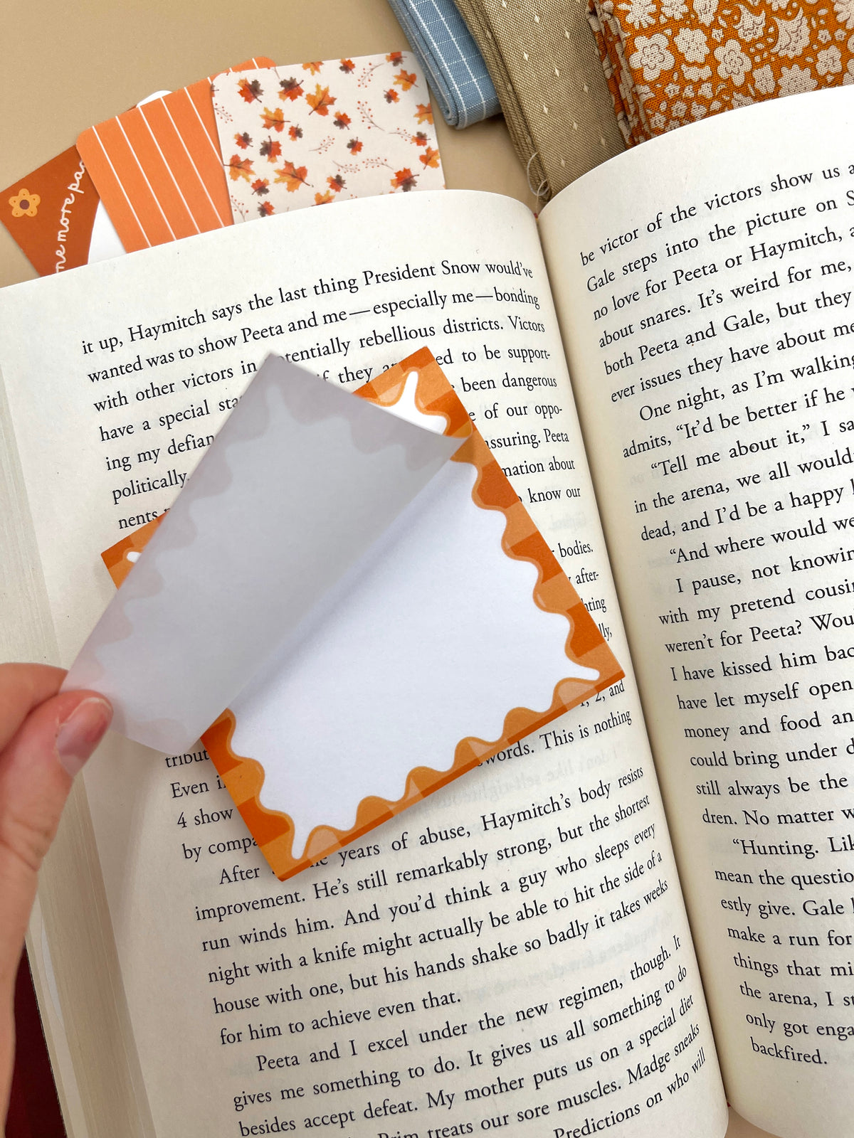 Handheld orange pumpkin-shaped sticky note with blank white sheet and scalloped border