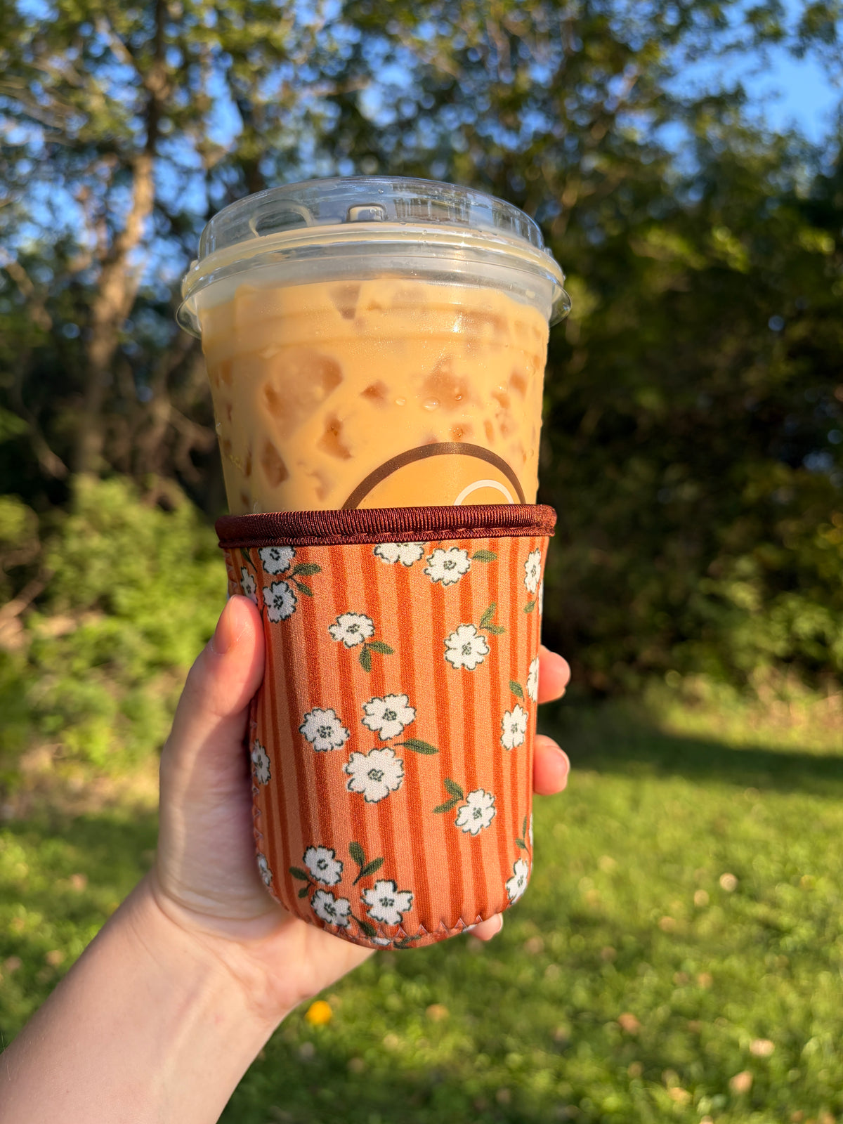 Orange autumn leaves cup sleeve with white and black floral pattern and cup holder
