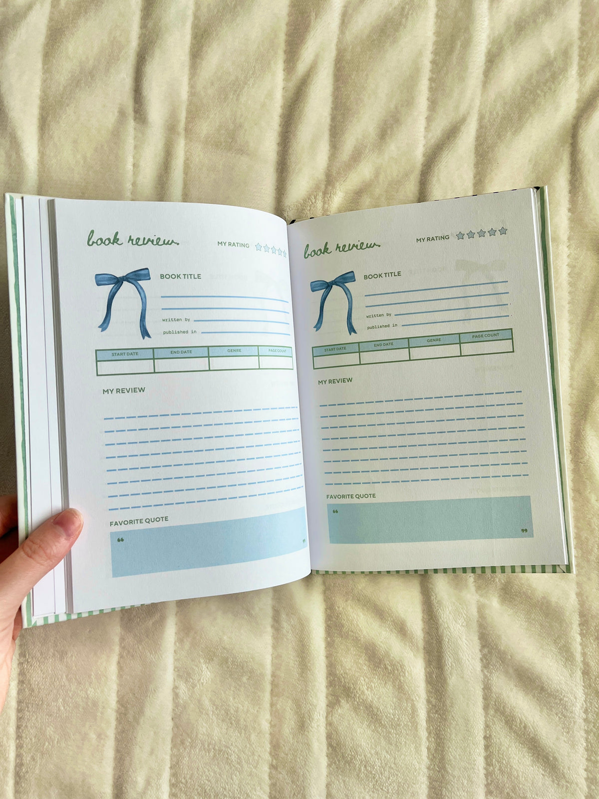 Open green striped journal with lined review pages and rating sections