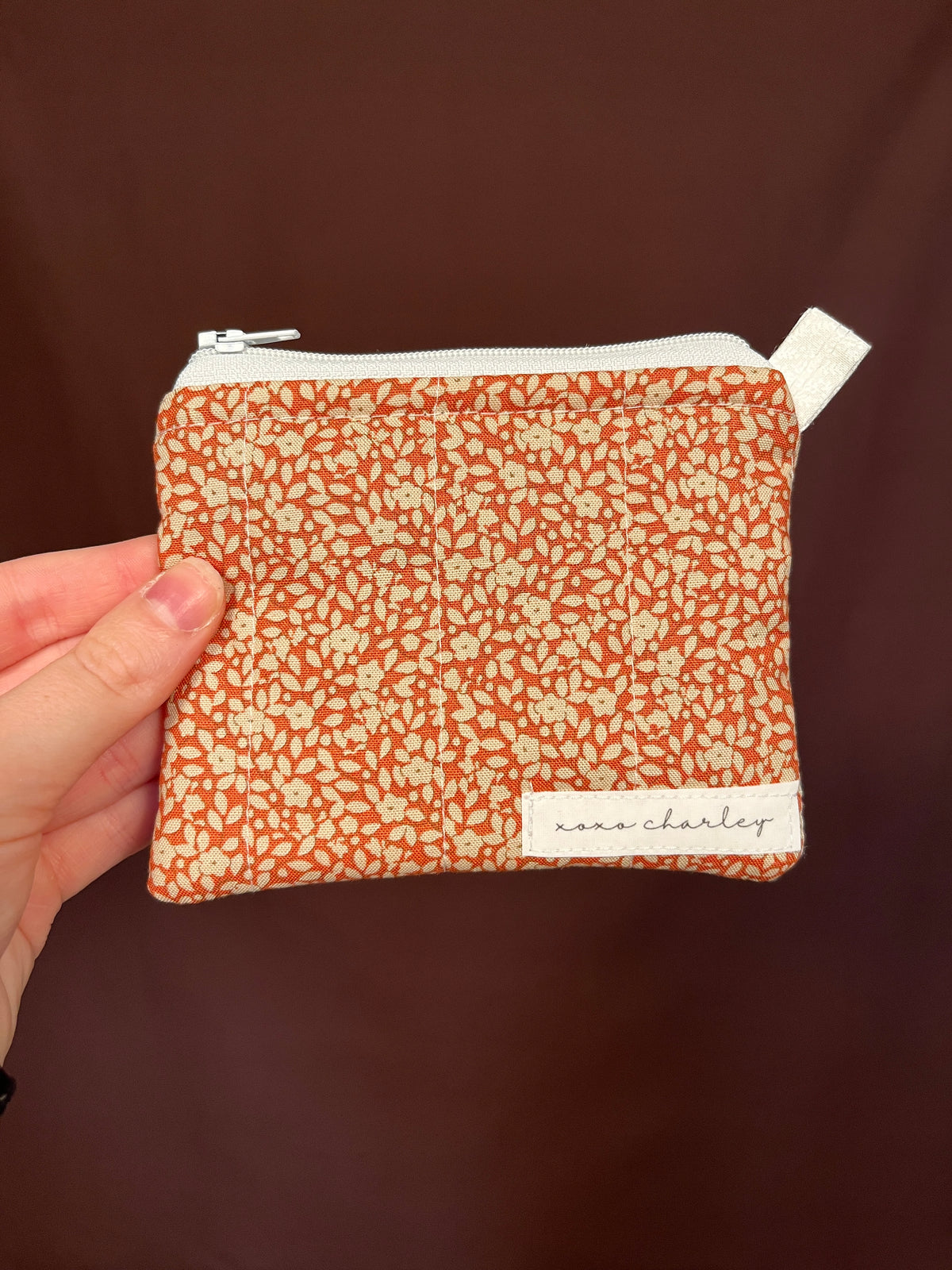 Orange floral keychain pouch wallet with white zipper and wristlet loop