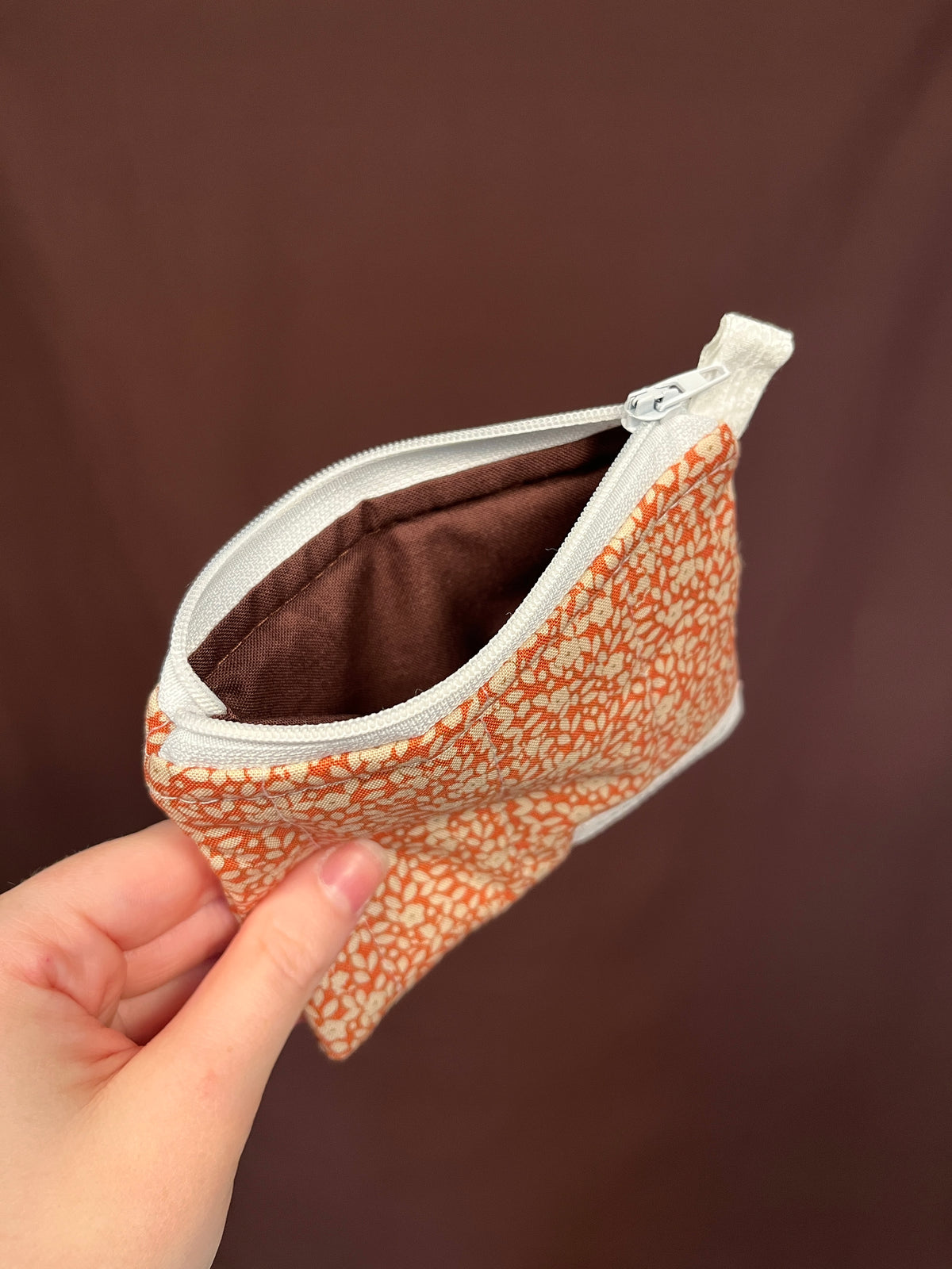 Orange floral keychain pouch wallet open showing fabric interior and zipper