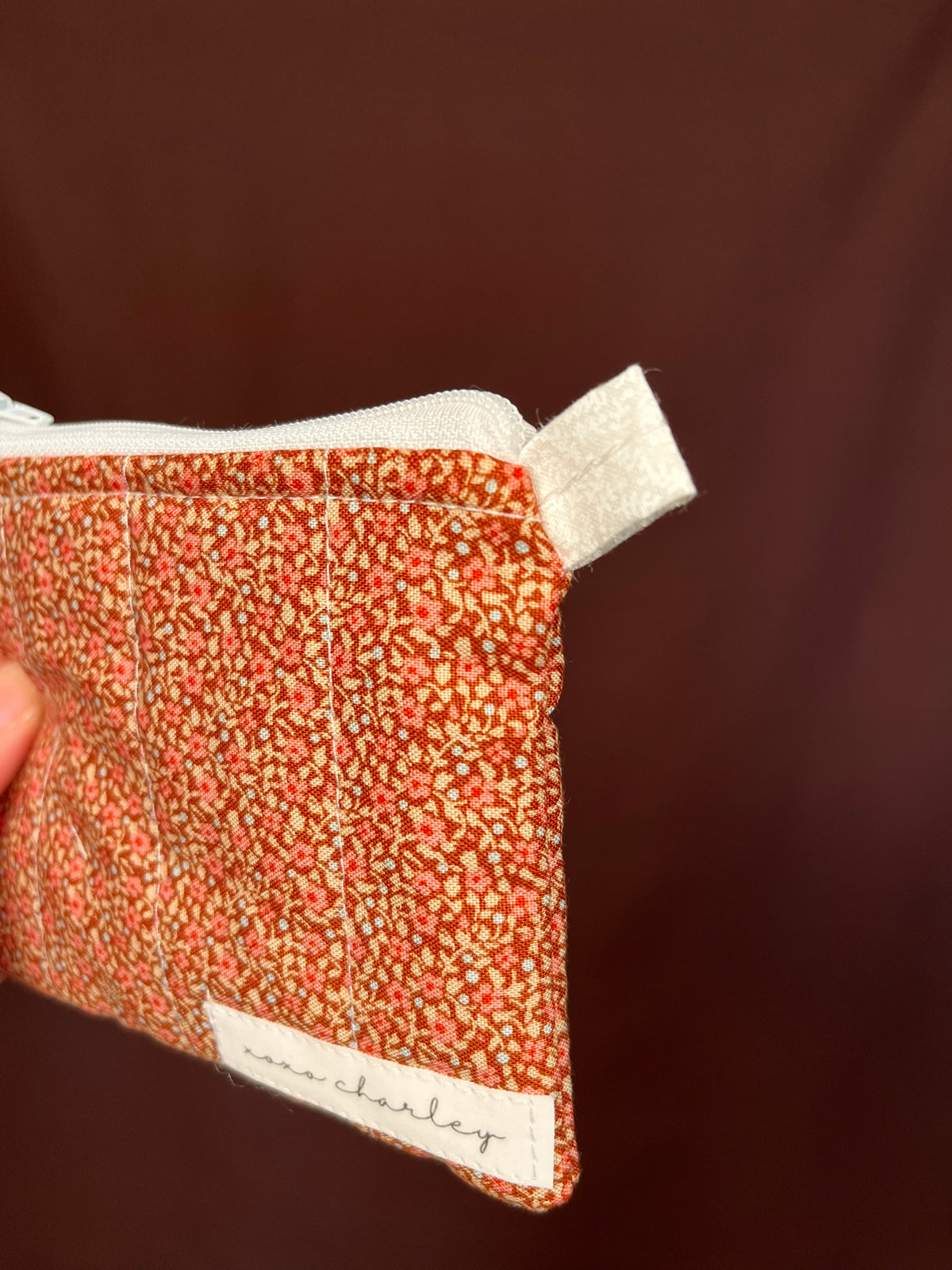 Orange speckled keychain wallet side view with white label trim