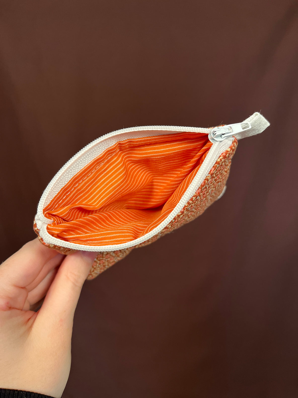Orange speckled keychain wallet open, showing orange striped lining