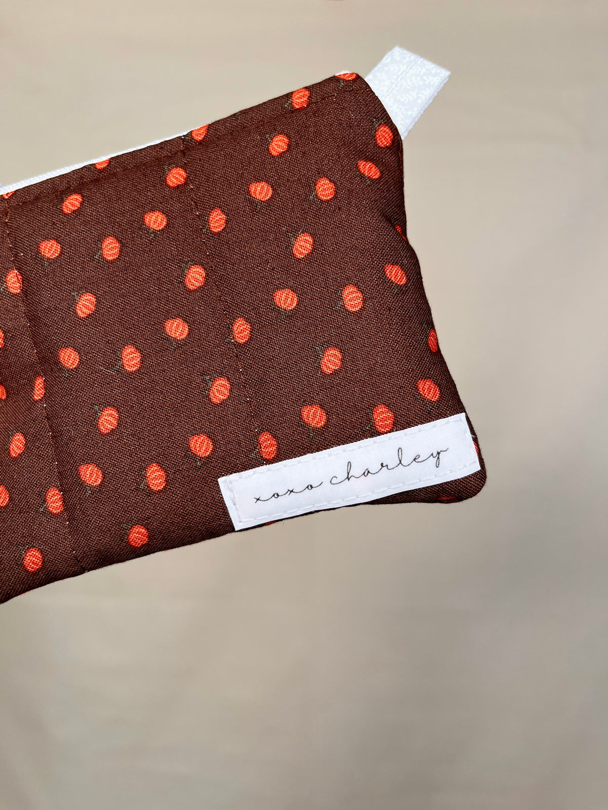 Mini pumpkin keychain wallet detail, dark brown fabric with orange printed pumpkins
