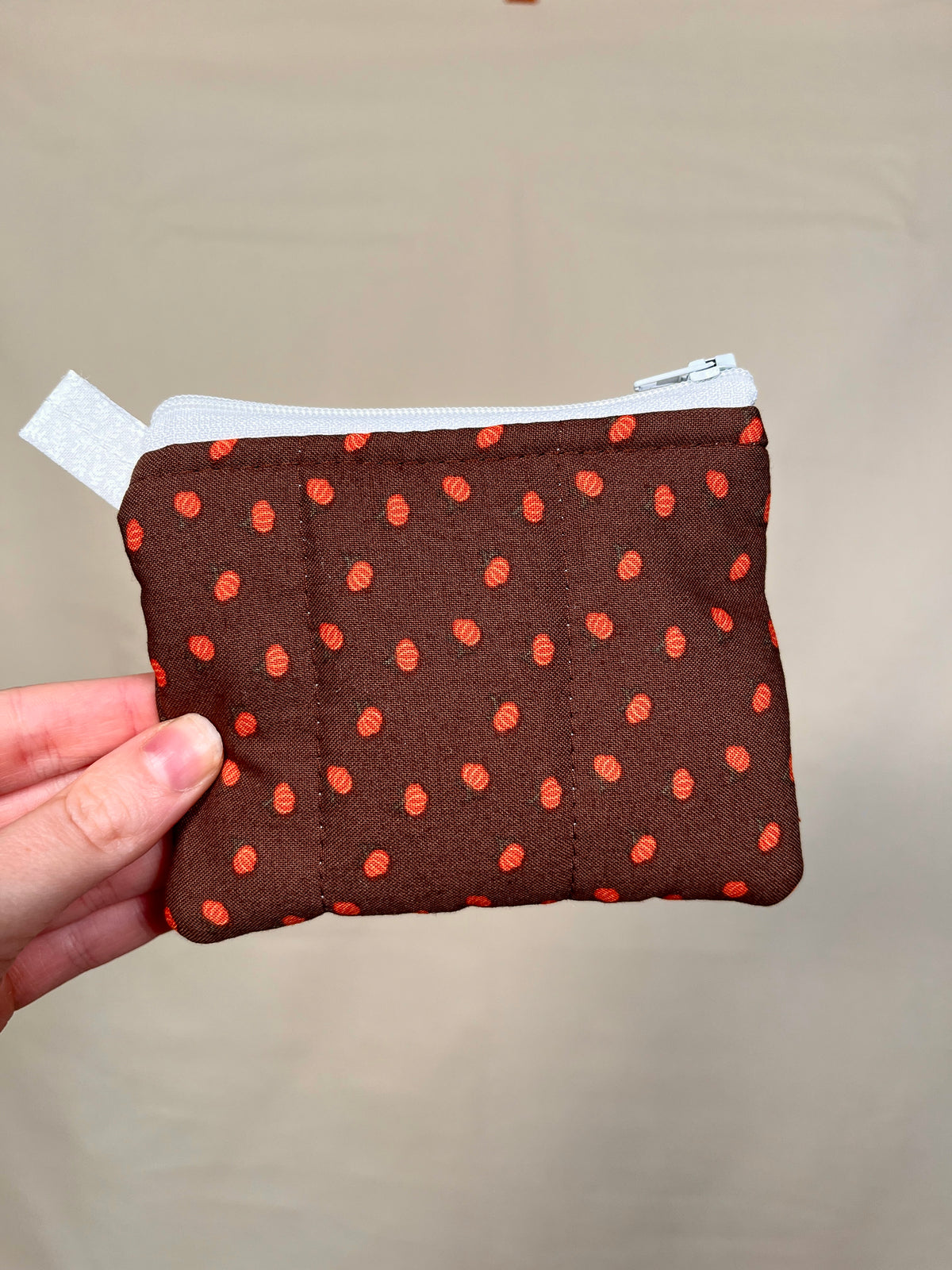 Mini pumpkin keychain wallet front, dark brown fabric with orange pumpkin dots