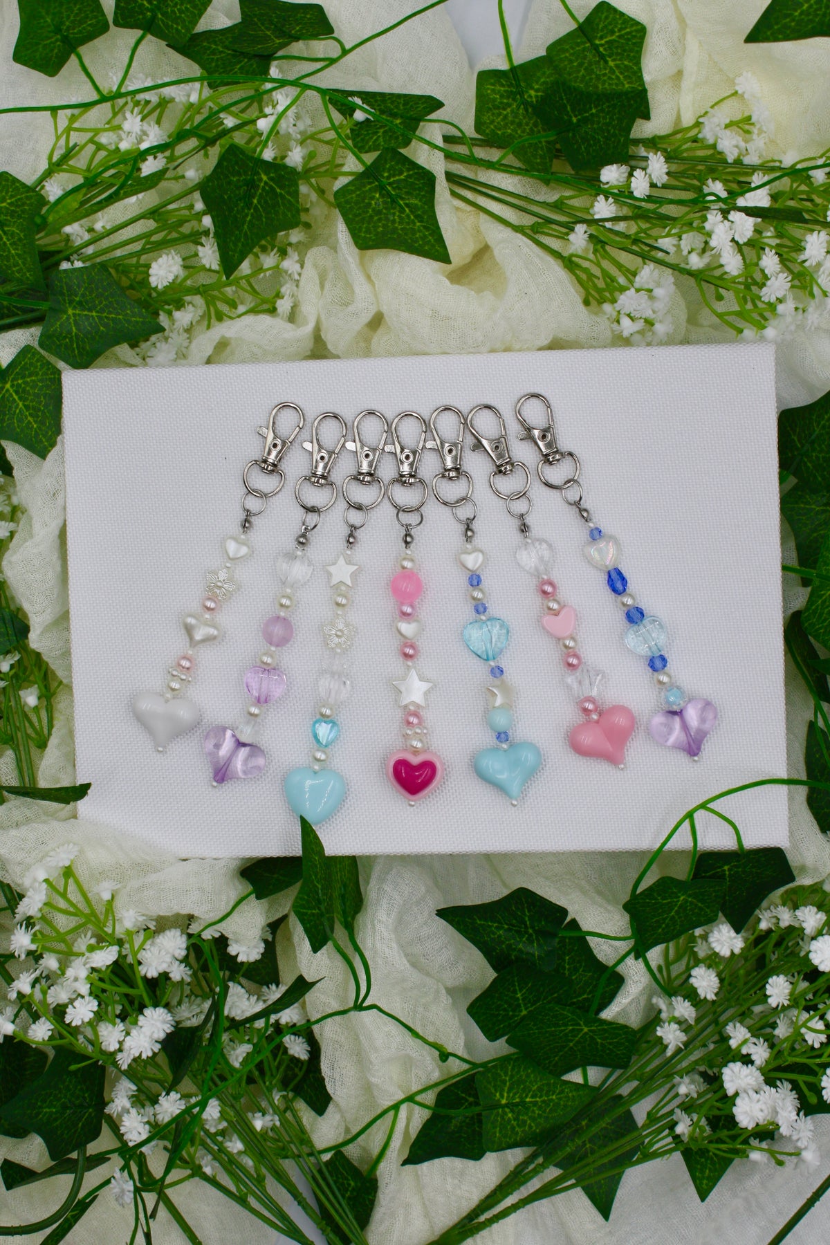 Assorted pastel beaded keychains with heart charms and metal key rings on display card