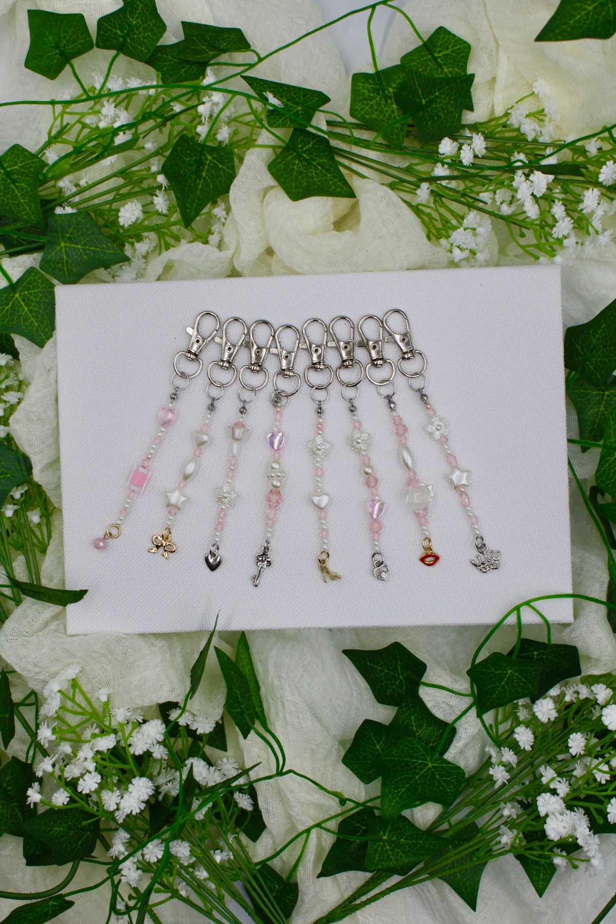 Beaded keychain set with silver-tone hooks and pink-and-clear beads on a display card