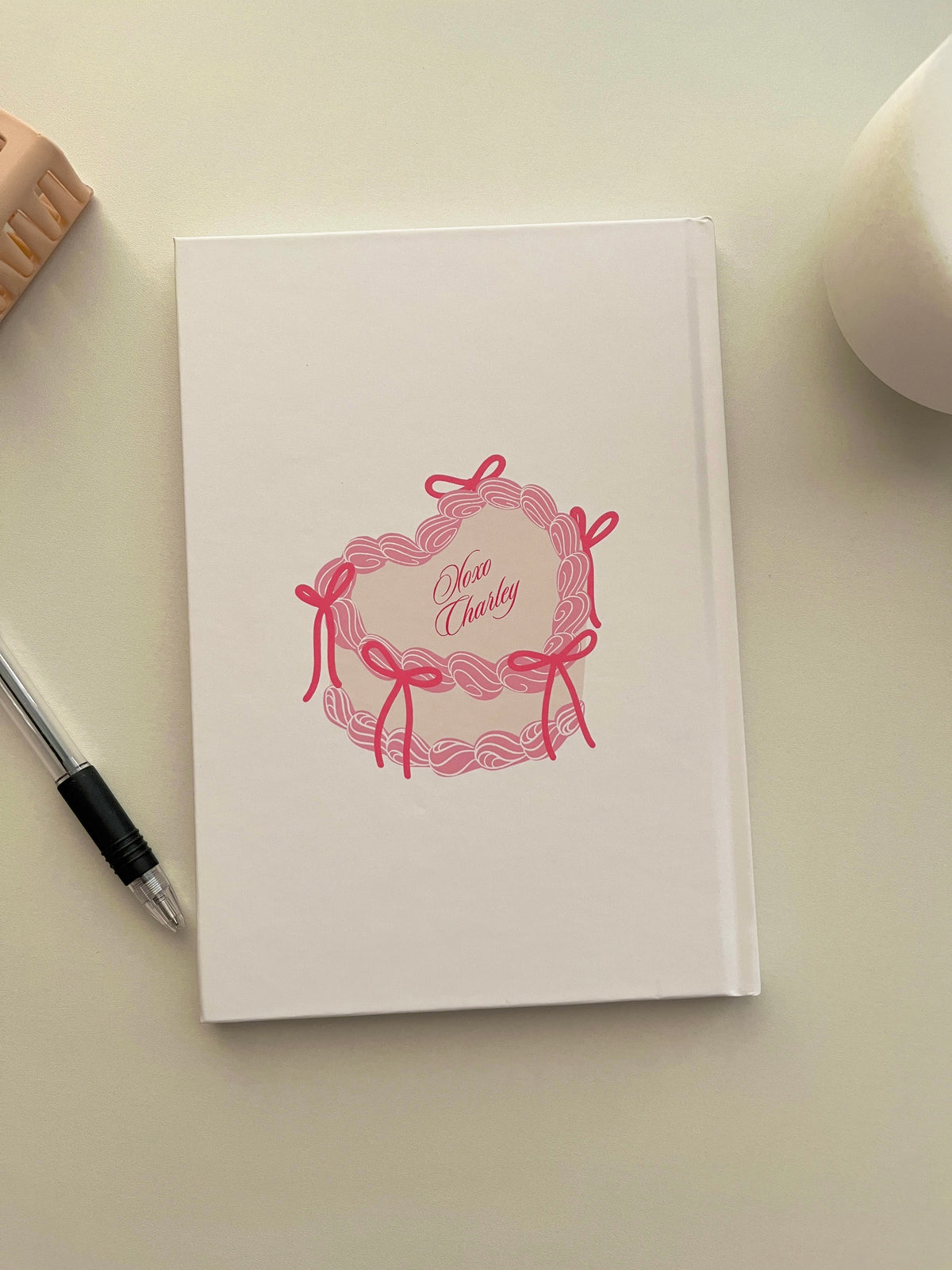 White journal cover with pink “Xoxo Charlie” cat illustration